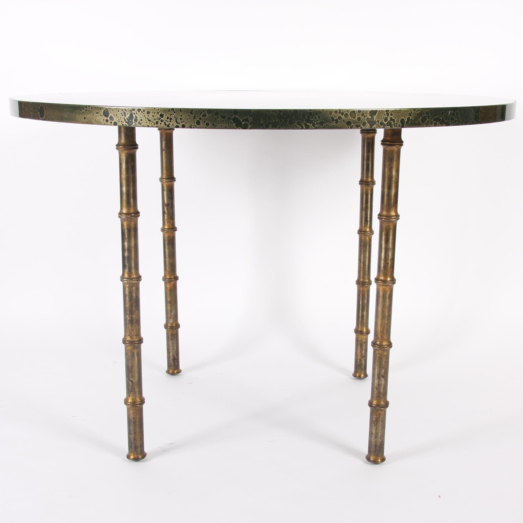 This stunning Maison Baguès style table, with a marble effect top speckled with gold, and gilt metal faux bamboo legs, dates back to 1970s France.