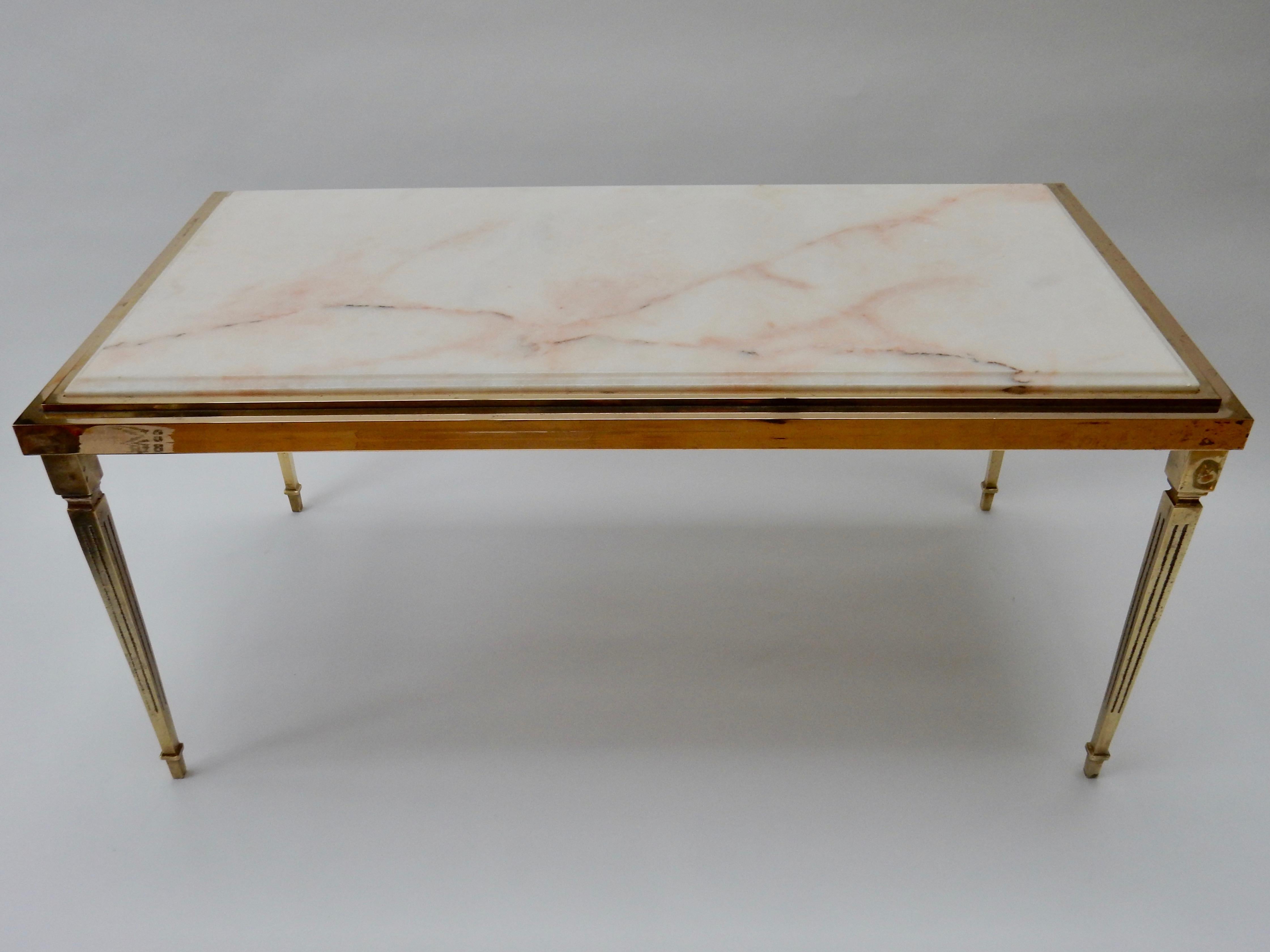 French Mid-Century Modern brass coffee table with light pink and cream marble top. 
 