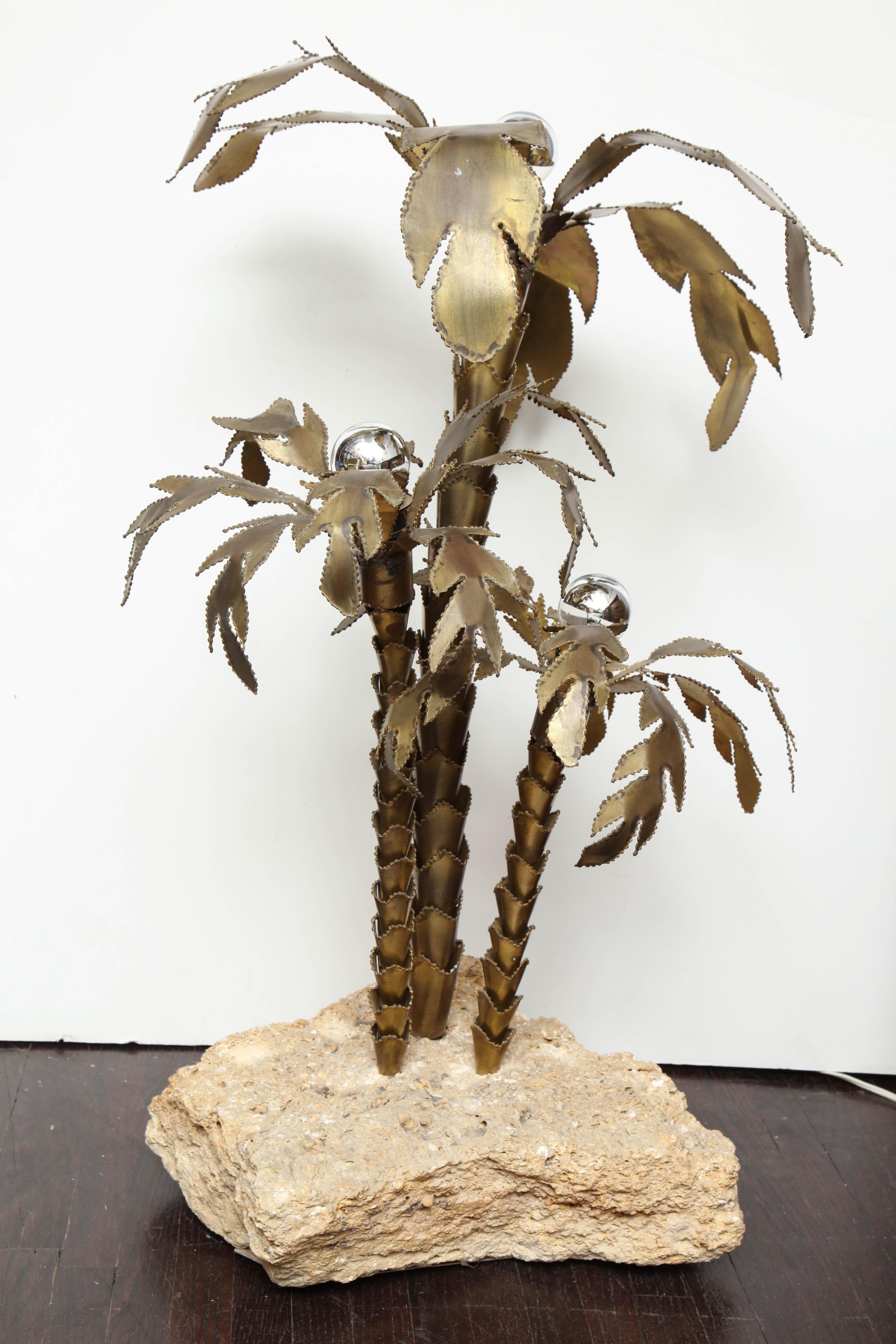 1970's French brass palm tree lamp with natural stone base. There are 3 light sockets on this lamp.
  