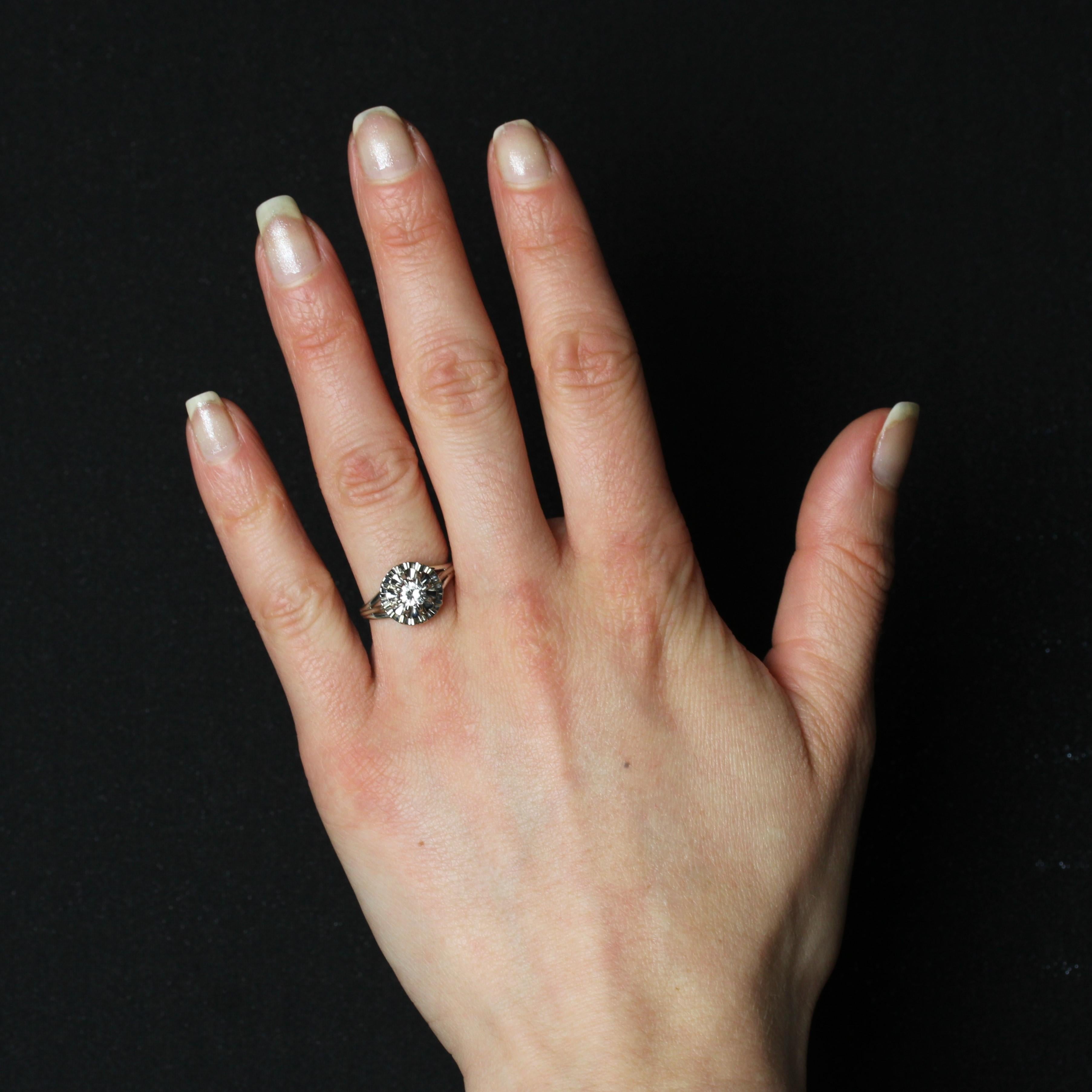 Ring in 18 karat white gold, eagle head hallmark and platinum dog's head hallmark.
This voluminous flower ring is formed of two applique corollas and set with a modern-cut diamond in the center. The band is double.
Weight of the diamond : 0,30 carat