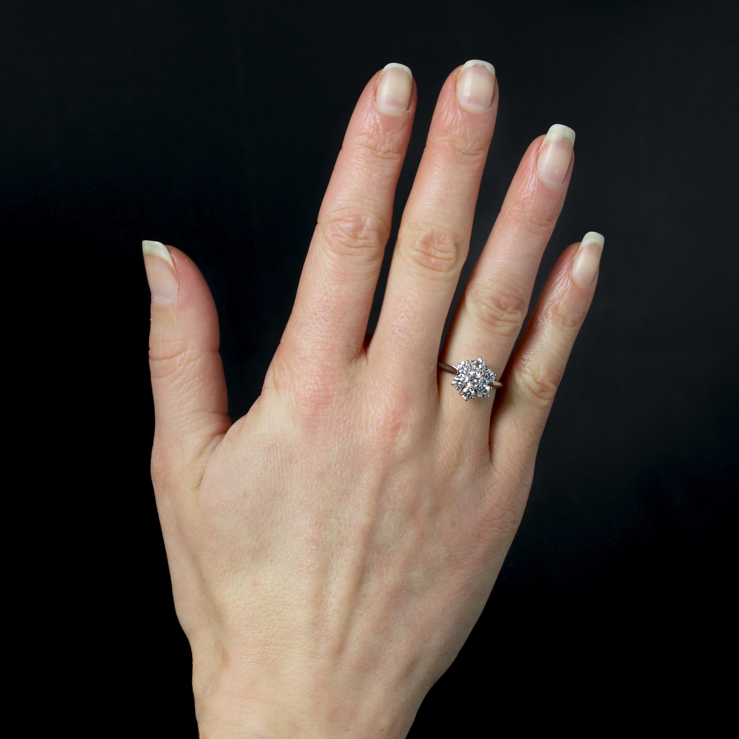 Anello in oro bianco 18 carati, marchio di fabbrica con testa d'aquila.
Questo incantevole anello vintage presenta un'incastonatura a forma di fiocco. Ogni ramo è incastonato con un moderno diamante a taglio brillante tenuto a griffe, di cui quello