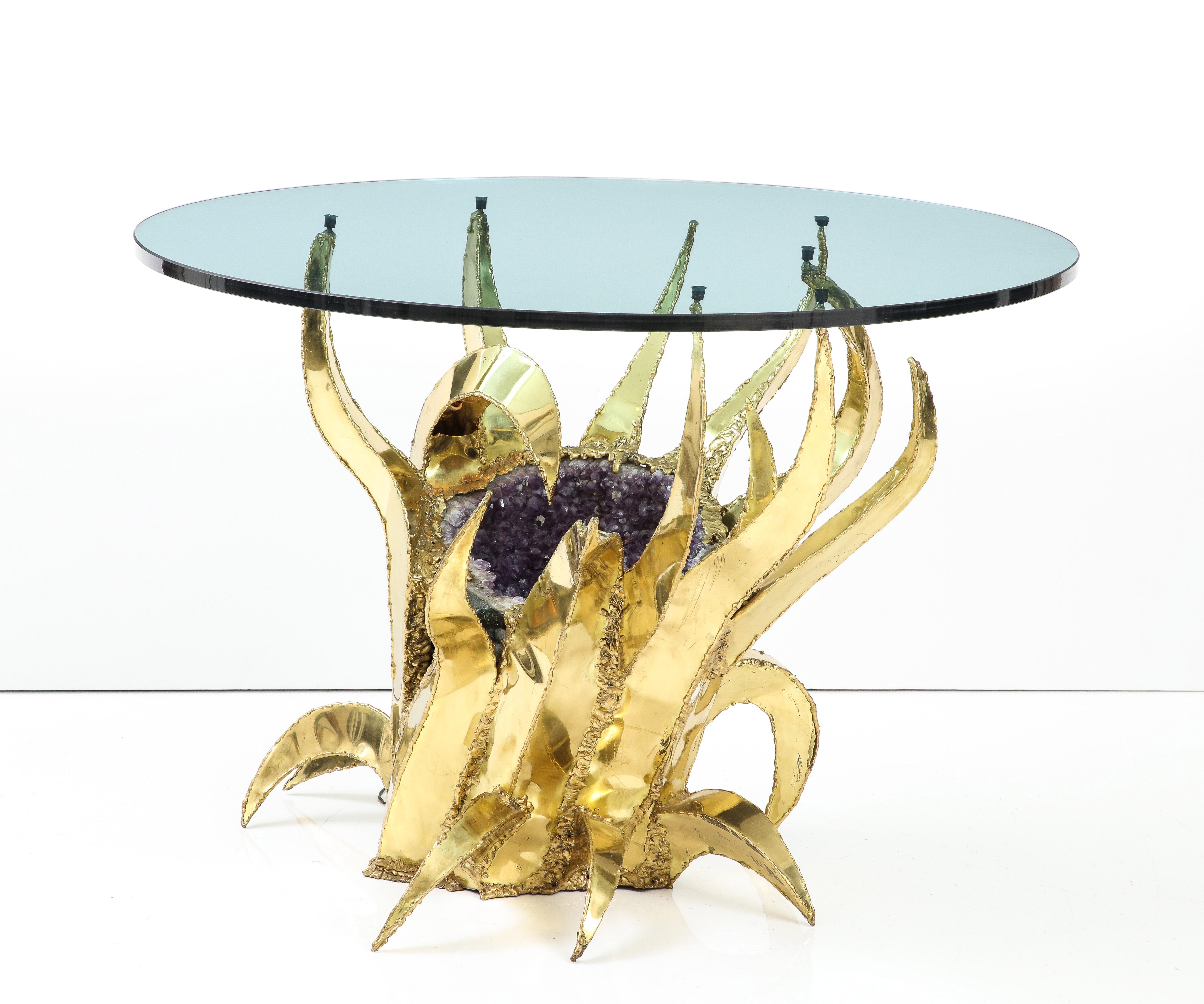 A wonderful sculptural brass 1970s French table with a large amethyst crystal cluster at its center illuminated with an adjoining light socket. Can be used as a center table or a dining surface. Beautiful and unique.