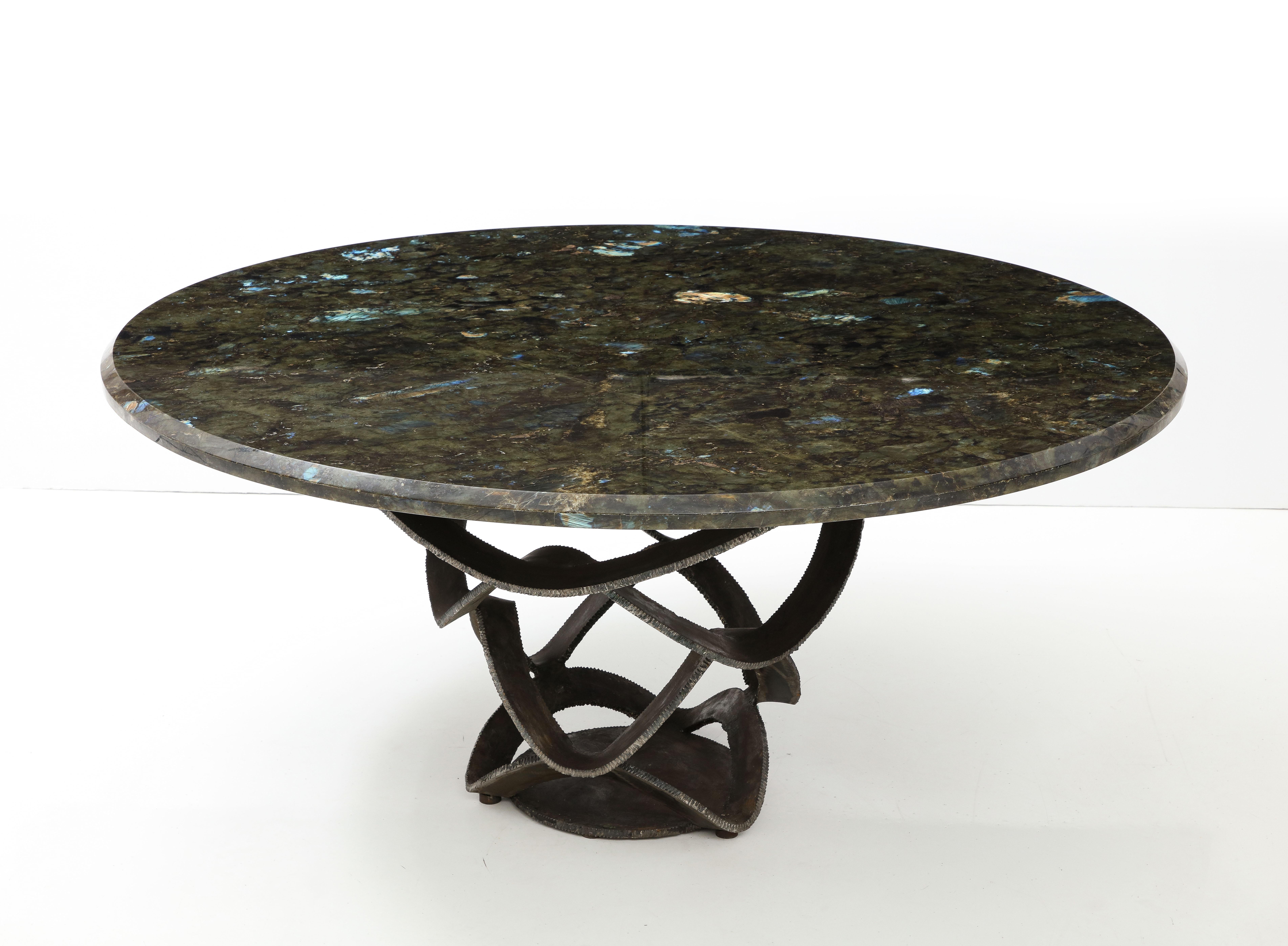 A beautiful luxurious French sculptural 1970s center or dining table composed of a forged iron base and a beautiful labradorite stone top. 