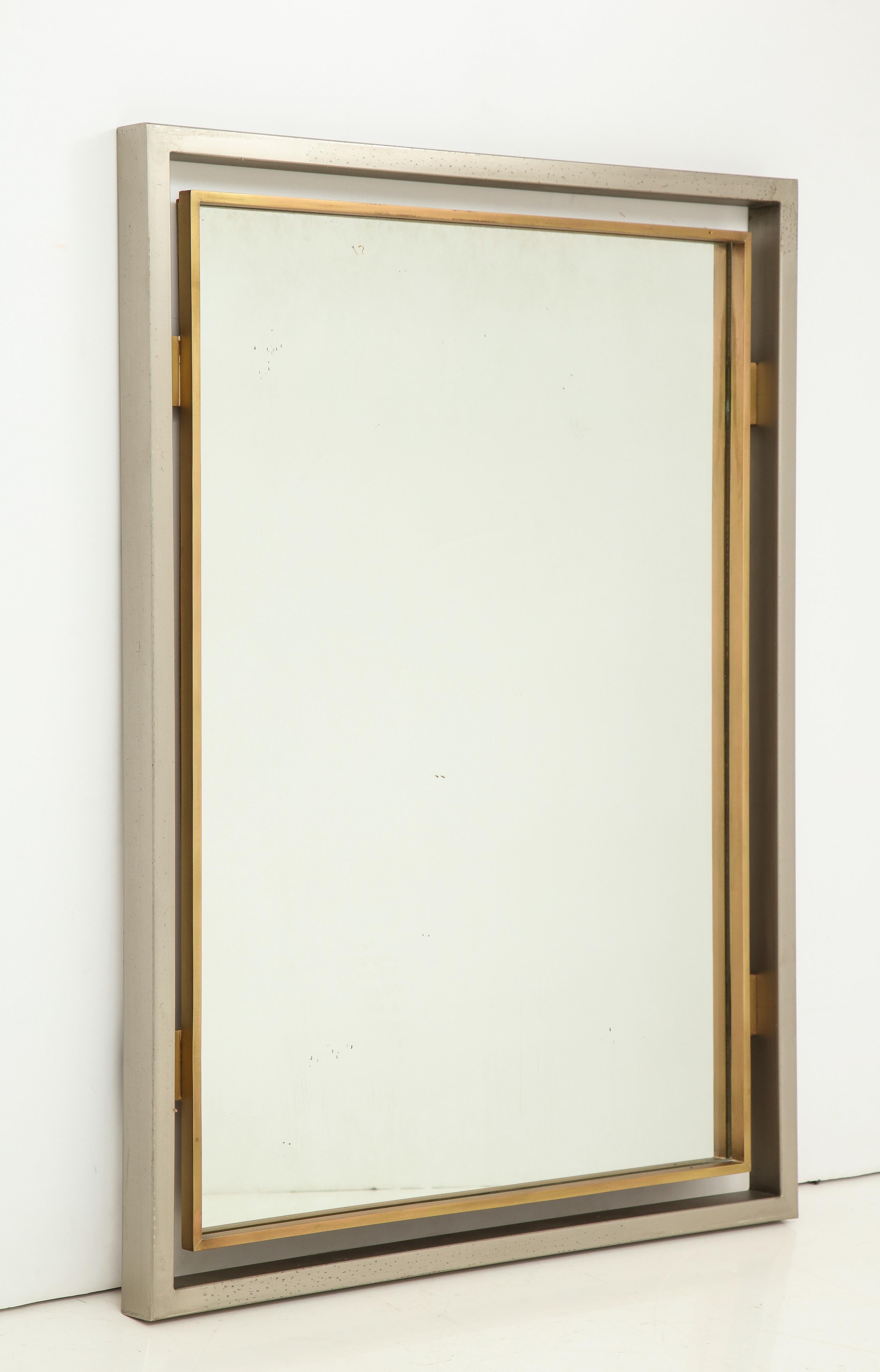 Solid steel and brass elegant Modernist mirror by Guy Lefevre for Maison Jansen, French 1970s. 
Oxidation spots on steel frame (please see pictures), otherwise in great vintage condition.
 