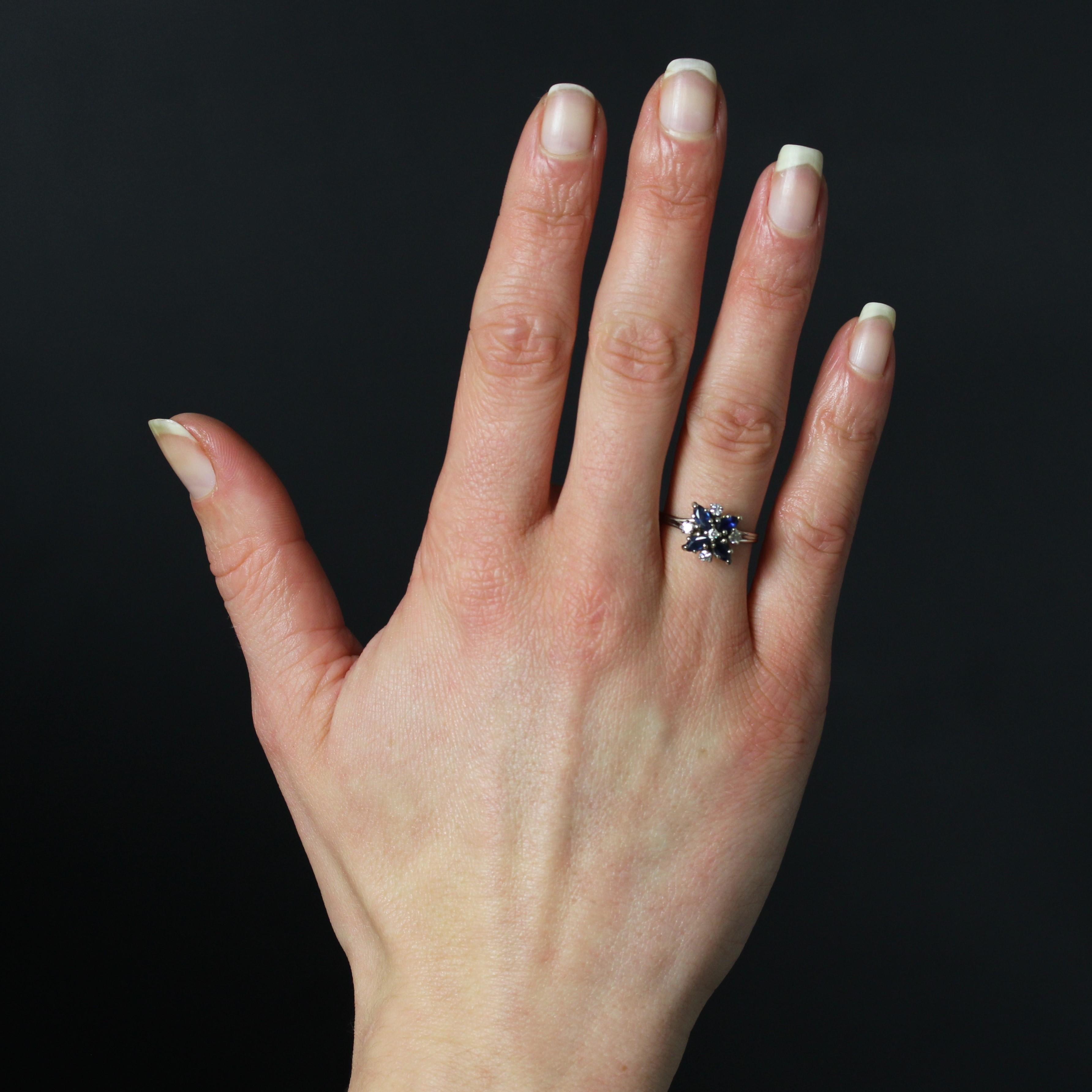 Anello in oro bianco 18 carati, marchio di fabbrica con testa d'aquila.
Questo anello vintage in oro bianco presenta un'originale incastonatura a forma di piccolo fiocco di neve. La parte superiore è ornata da quattro zaffiri taglio navette e cinque