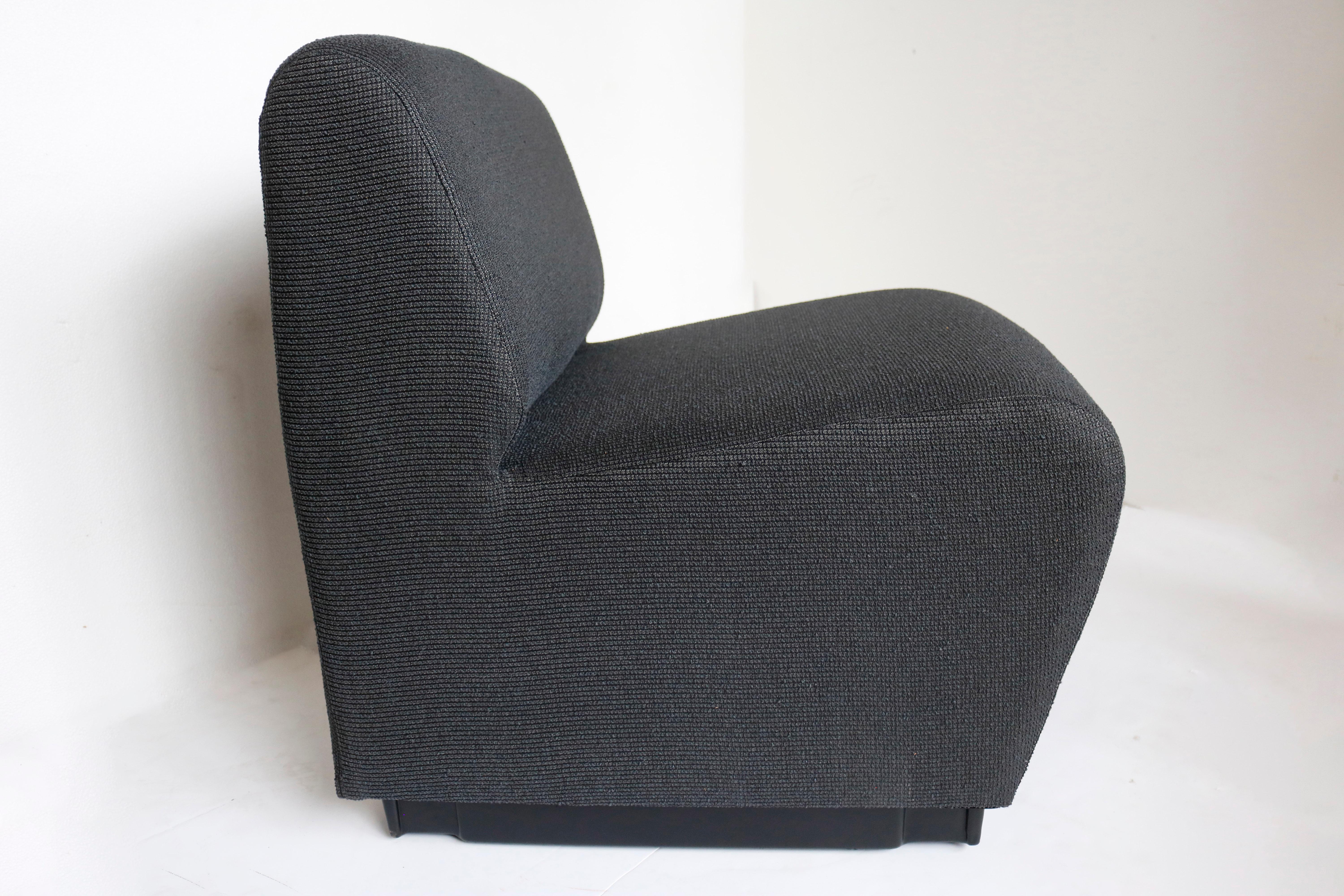 Una cómoda y minimalista silla zapatilla francesa de los años 70. Se asienta sobre una moderna plataforma negra y está tapizada en tela gris marengo.