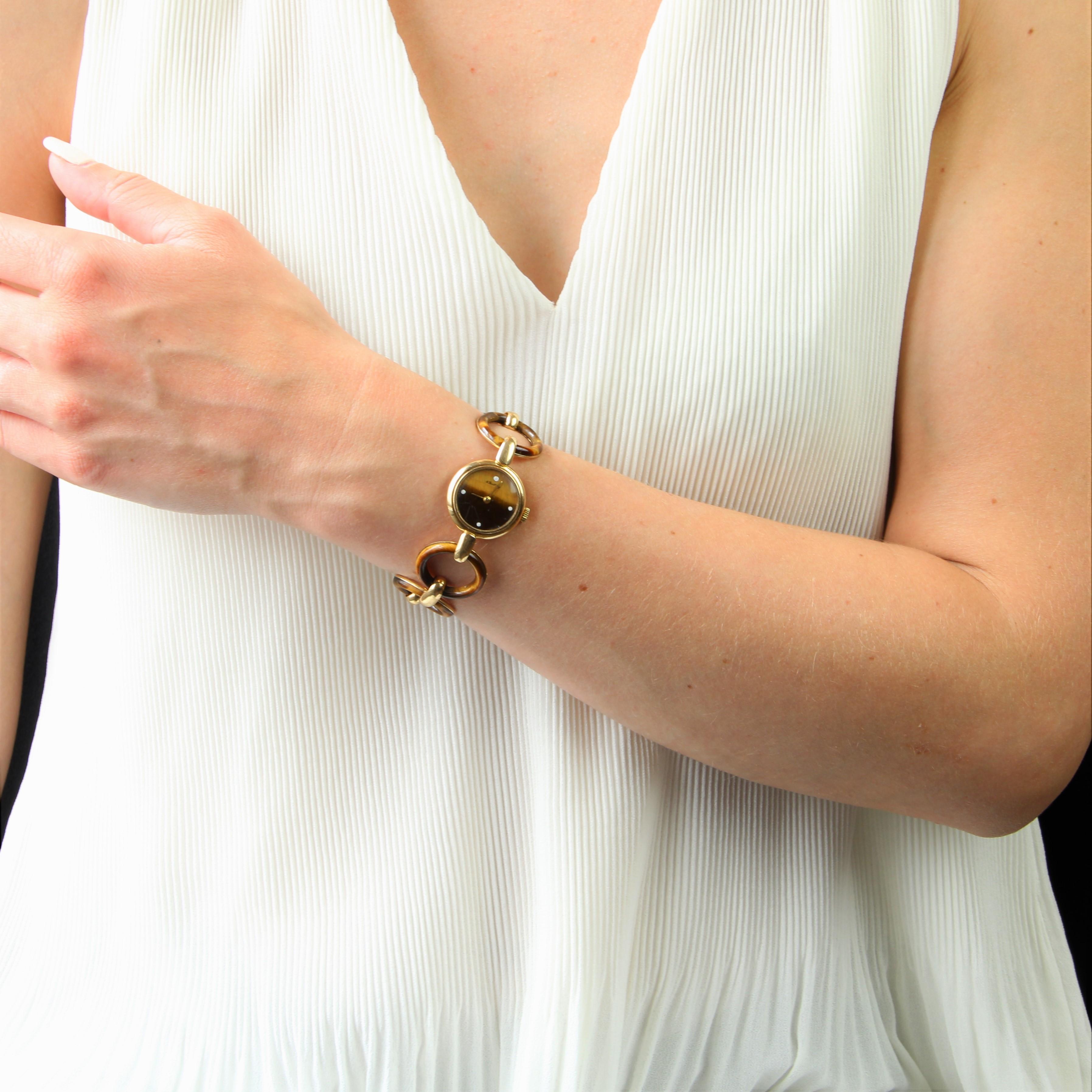 Lady's watch in 18 karat yellow gold, eagle head hallmark.
Ladies' watch with round case, gilded hands and white enamelled tiger's eye back with 4 cardinal points, marked A. Barthelay. The bracelet features 7 onyx discs set in gold, held together by