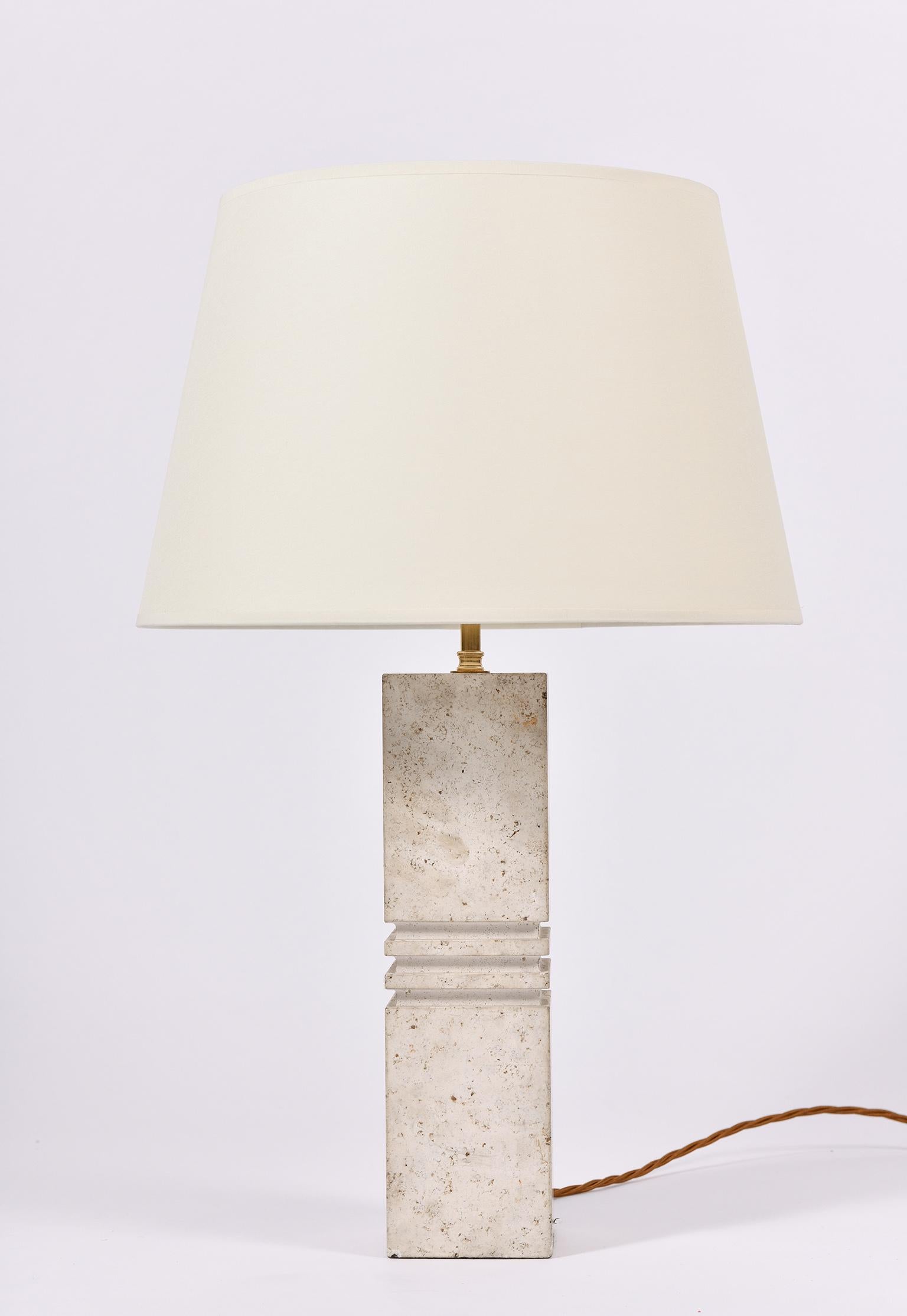 A carved travertine square column table lamp
France, circa 1970.