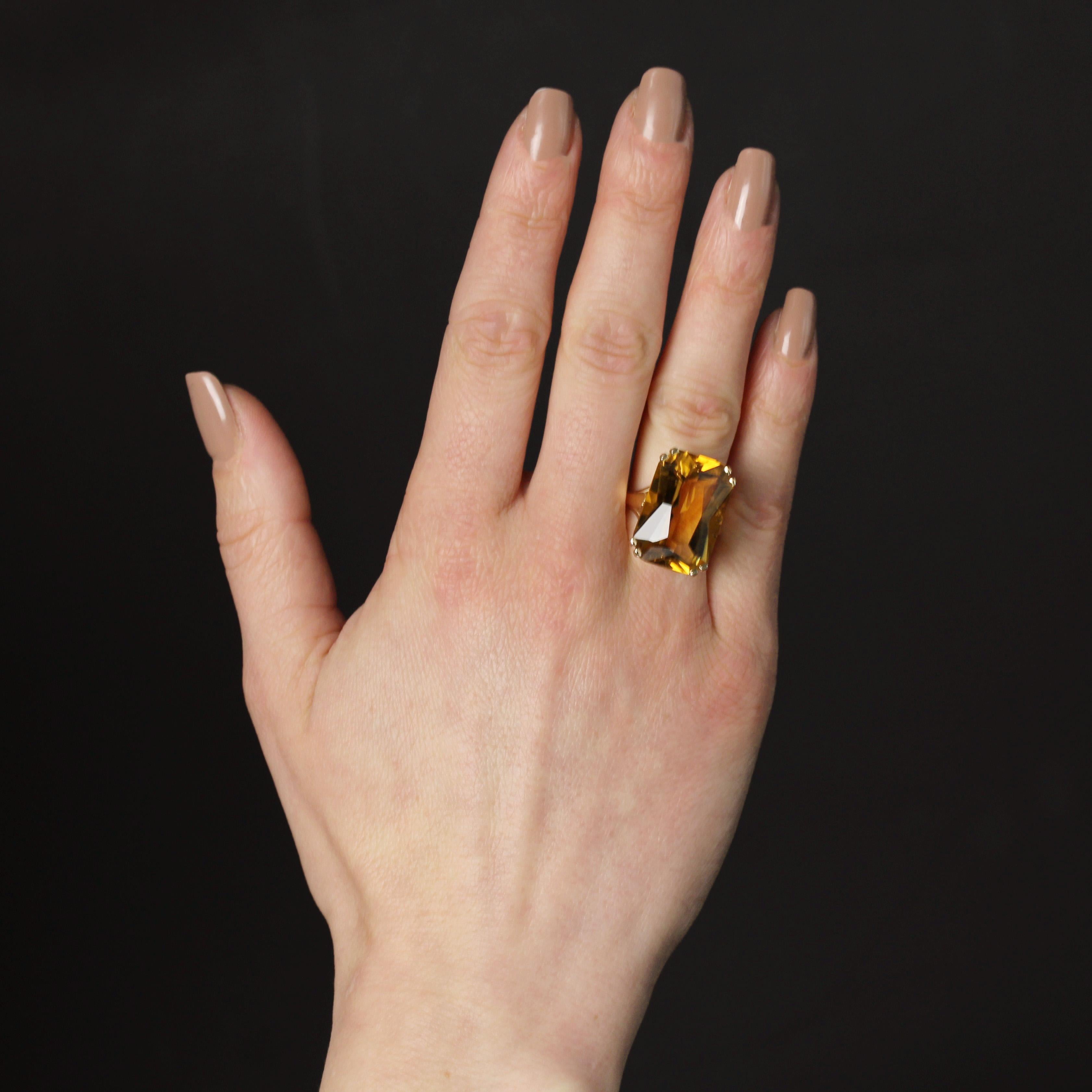 Anello in oro giallo 18 carati, punzone a testa d'aquila.
Voluminoso anello in oro giallo con 2x4 griffe che reggono un grande citrino taglio smeraldo. Il cesto è ornato da motivi traforati a forma di fleur-de-lys.
Peso del citrino: 21 carati