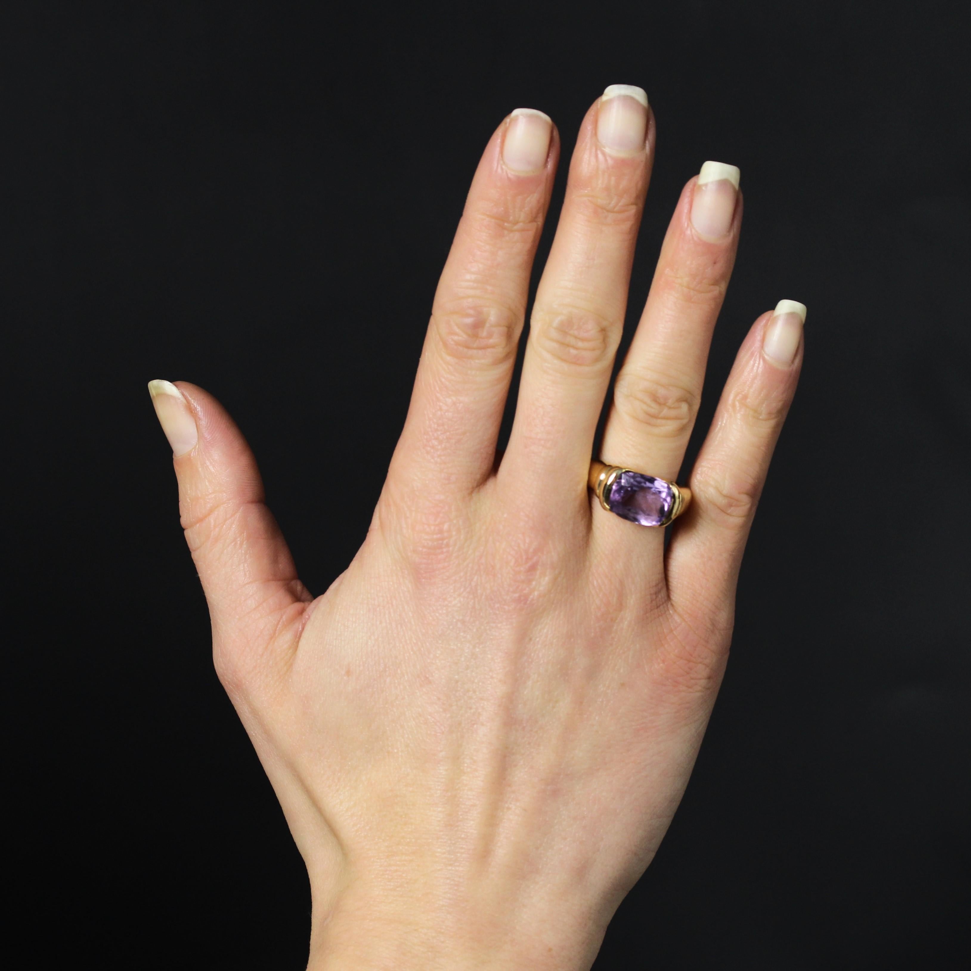 Ring in 18 karat yellow gold, eagle head hallmark.
This elegant antique ring features a wide band holding a cushion-cut amethyst in a half-moon setting at the top. The ring is gadrooned on either side of the center stone.
Total weight of the
