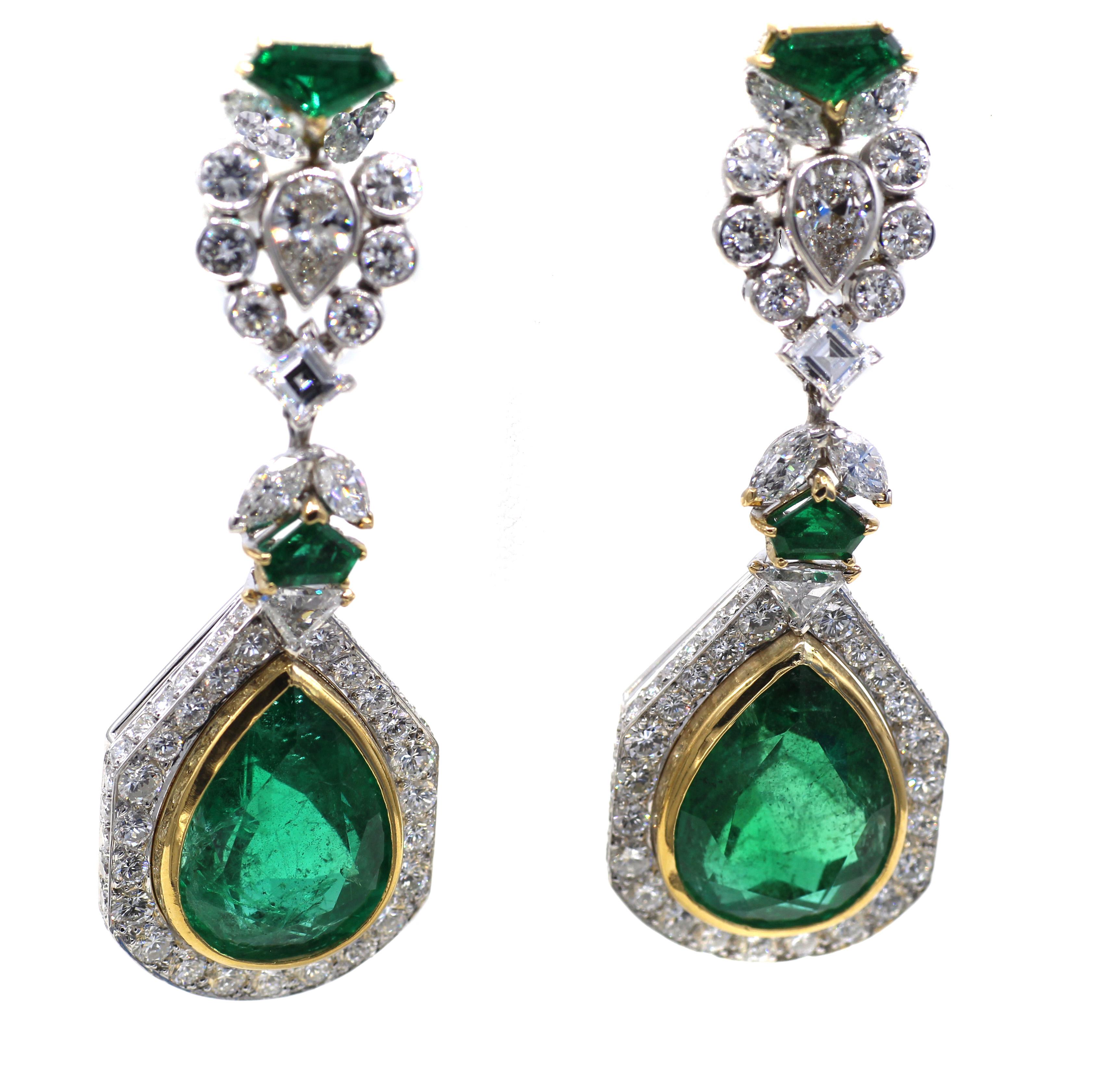 Beautifully designed and masterfully handcrafted these French 18 karat gold ear pendants feature 2 perfectly matched deep forest green pear shape emeralds weighing 14.15 carats and 14.19 carats set in a bezel of yellow gold and surrounded by bright