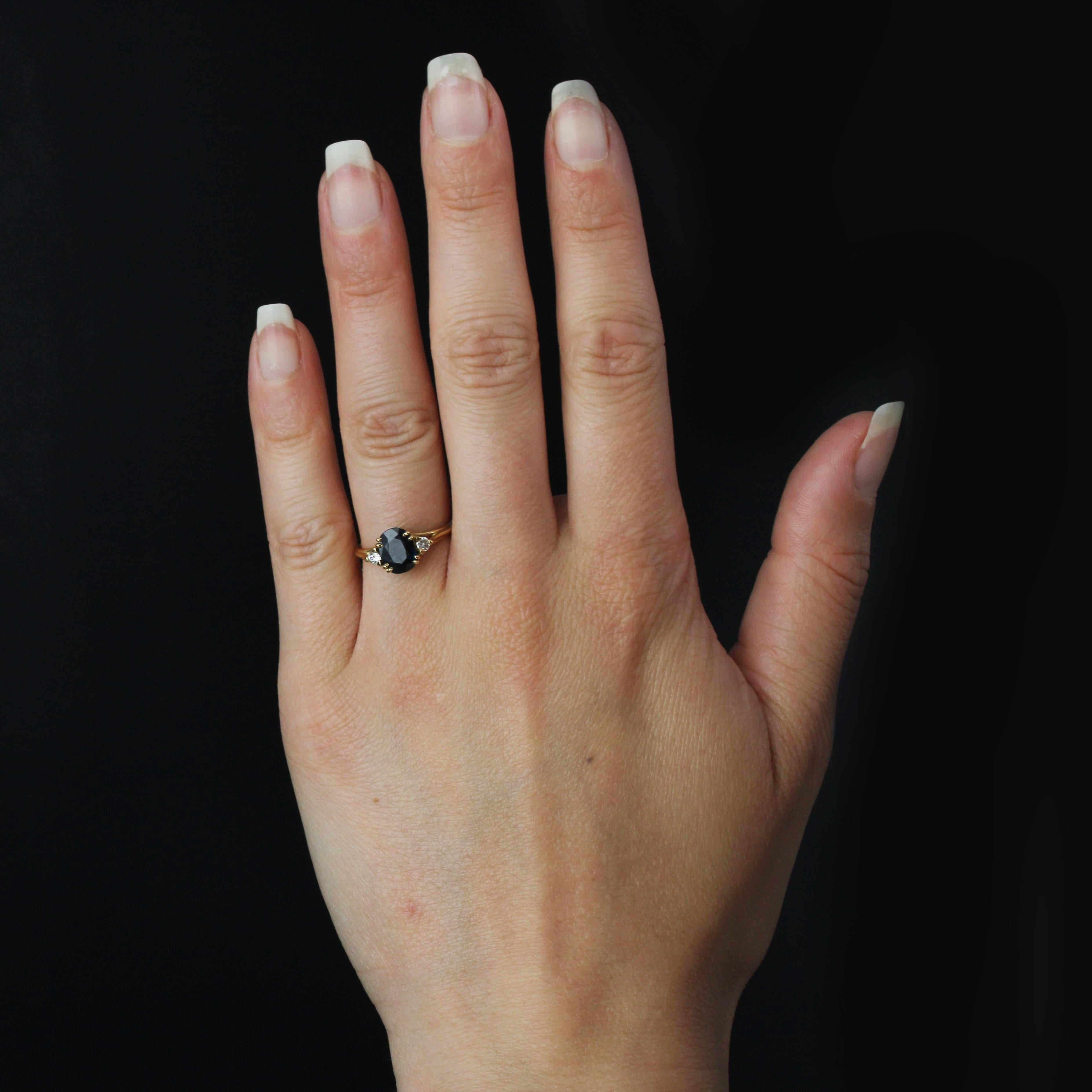 Ring in 18 karat yellow gold, eagle head hallmark.
A fine vintage ring with 3 fine gold wires holding an intense oval sapphire set with 4x2 claws. On either side, at the start of one of the rings, a modern brilliant-cut diamond is held by 3 flat