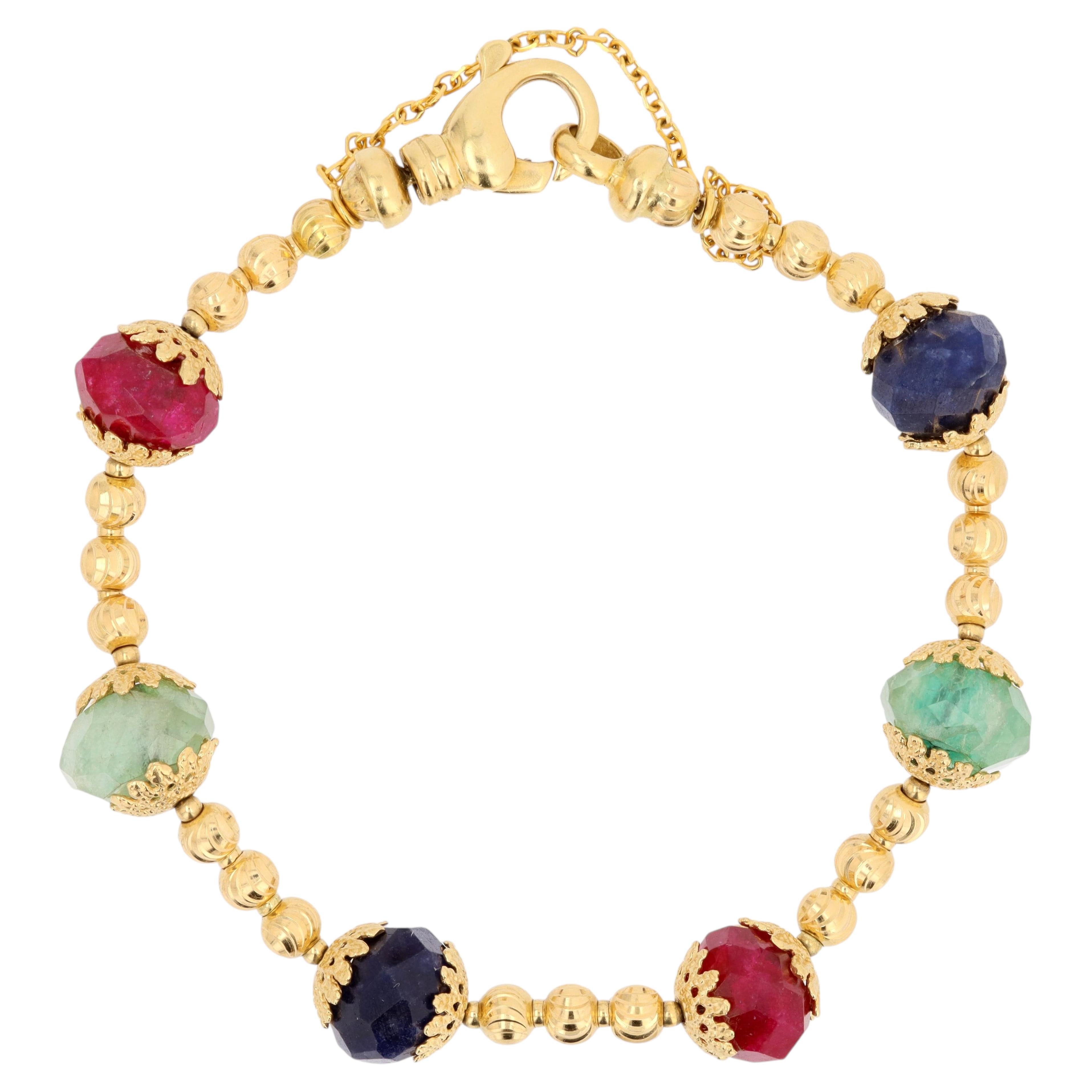 Bracelet en or jaune 18 carats, saphirs, rubis et émeraudes des années 1980 en vente