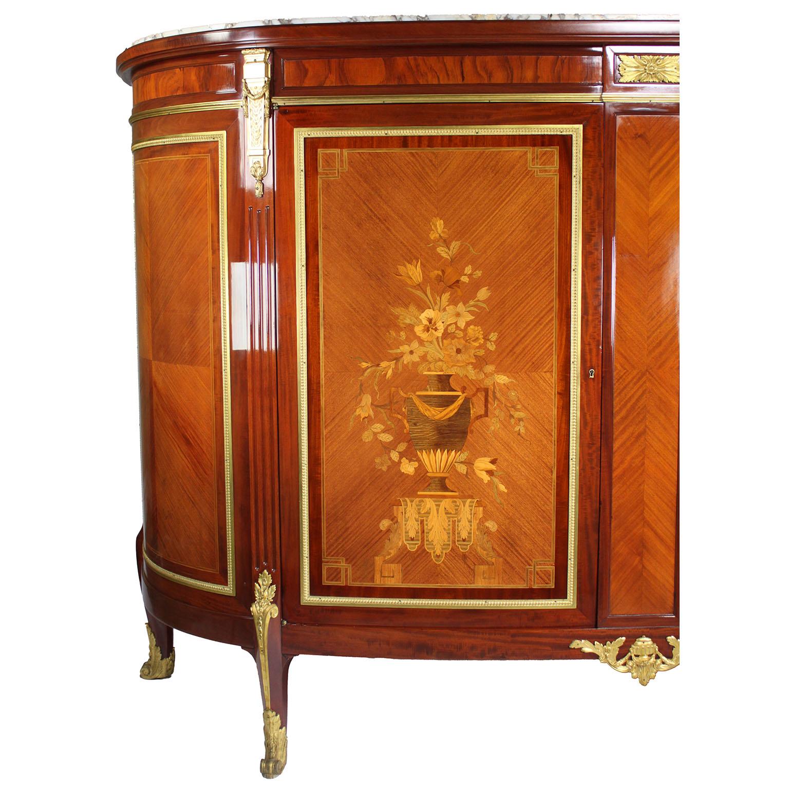 A Fine French 19th-20th Century Louis XV Style Mahogany, Satinwood and Tulipwood Marquetry Gilt-Bronze Mounted Two-Door Buffet Server China Cabinet with marble top. The slender and tall twin-door cabinet with rounded sides, ormolu trim-mounts with