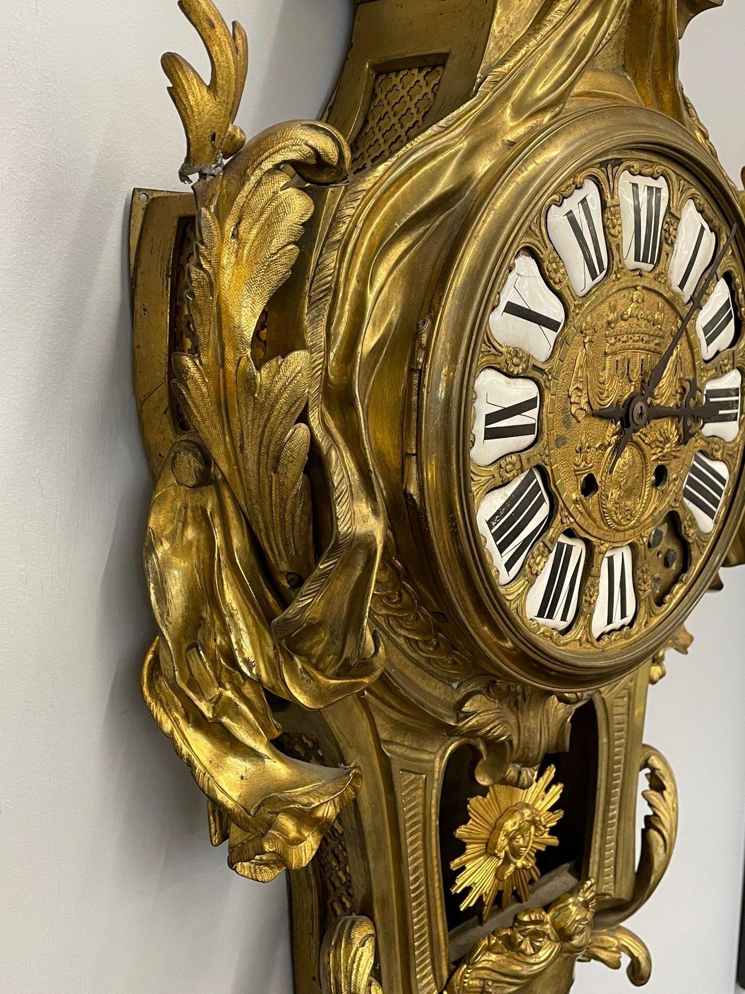 A French Bronze Wall, Cartel Clock Late 19th Century, Solid Bronze, Figural 
 
A fine solid bronze large and impressive Wall or Cartel Clock having porcelain Cartouche Roman numerals, foliate pierced and engraved steel hands, count wheel bell