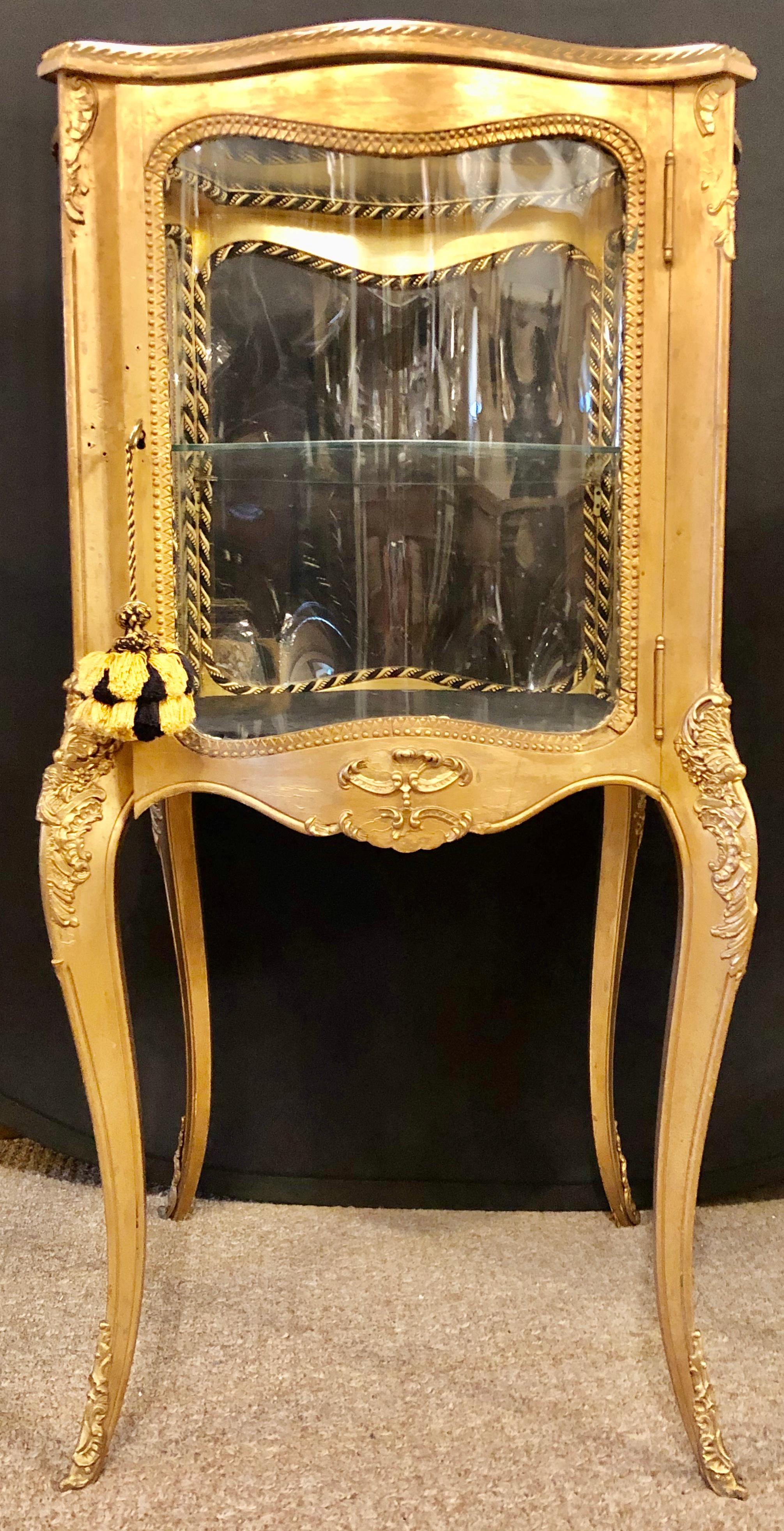 French 19th-20th century curio vitrine cabinet curved glass all round. This is a simply stunning Vitrine or Curio that can sit center room and is serpentine shaped on all sides. The Louis XV style cabinet is gilt wood with bronze mounts. If need be