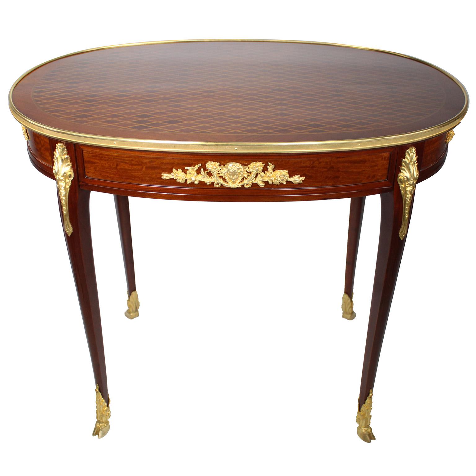 Raffinato tavolino ovale Guéridon francese del XIX-XX secolo in stile Luigi XV in mogano, legno di tulipano, intarsio e ormolu, attribuito a François Linke (1855-1946). Il piano ovale è impiallacciato in parquet a cubetti con motivo a diamante e