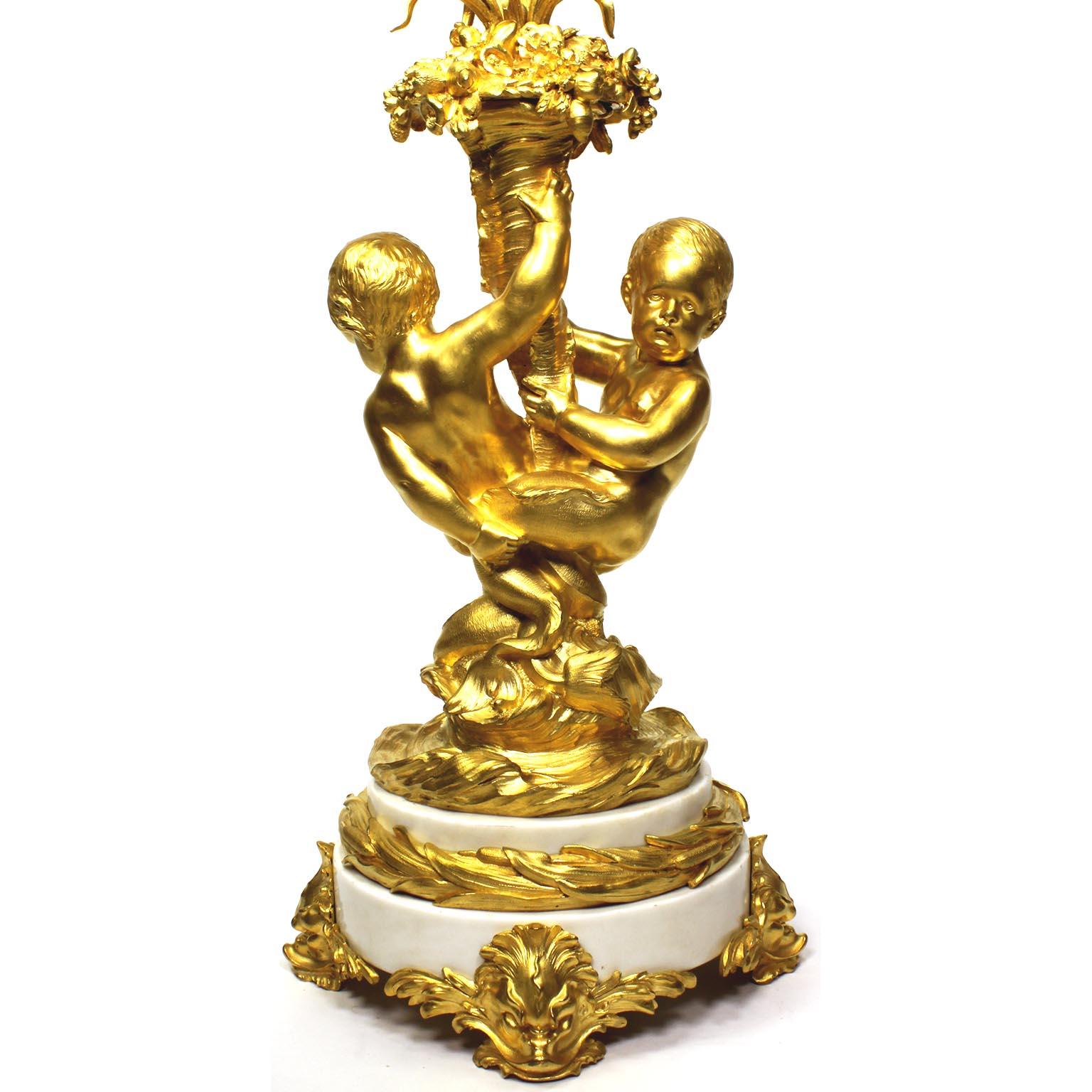 Très beau candélabre à trois lumières de style Louis XV en bronze doré et marbre blanc, attribué à François Linke (1855-1946). L'unique groupe allégorique et fantaisiste en bronze doré finement ciselé de la Belle Époque représentant une paire de