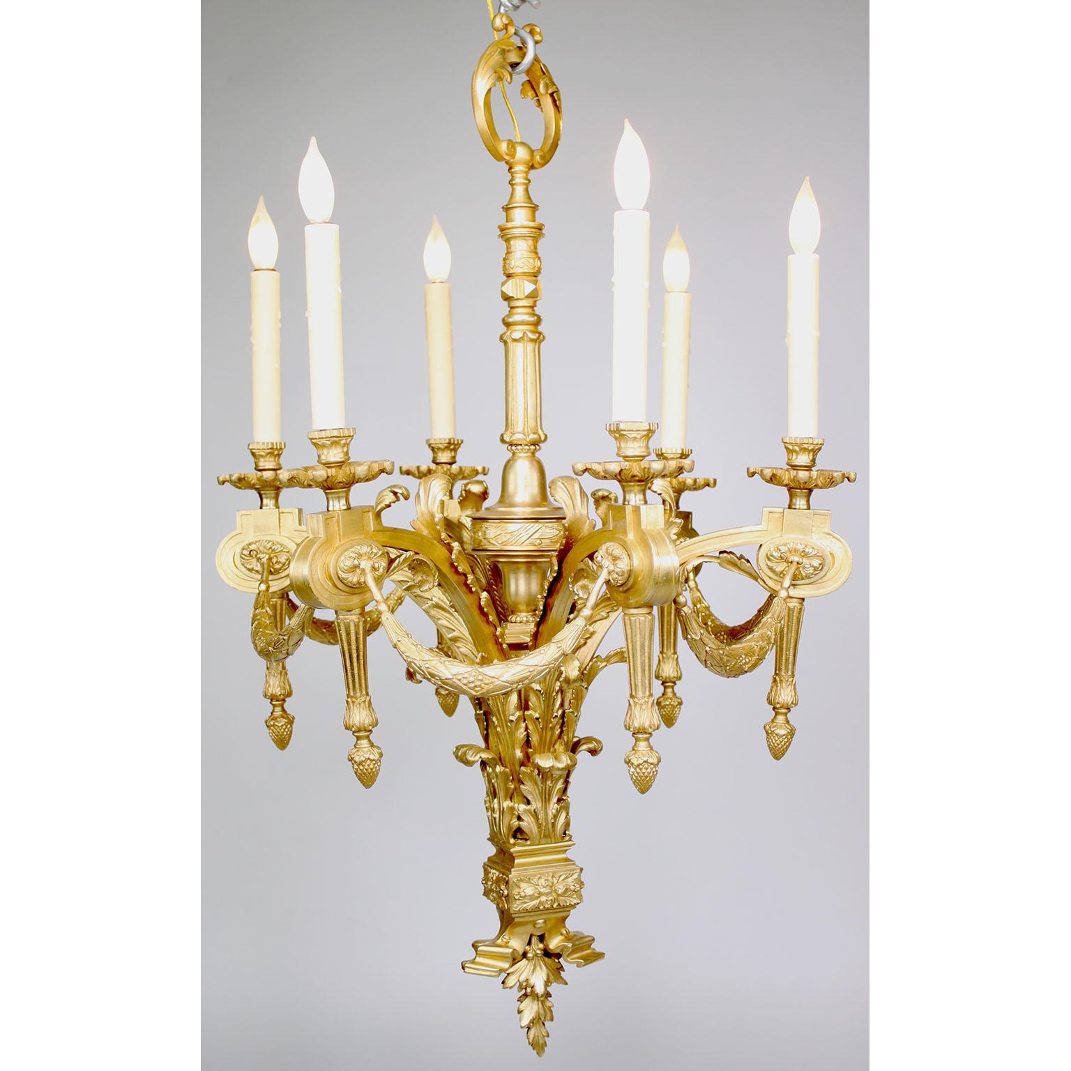 Charmant lustre à six lumières en bronze doré de style Louis XVI. Chaque bras de bougie est relié à des guirlandes au-dessus d'un cartouche se terminant par un gland. La tige centrale est ornée d'une boucle florale au-dessus d'une base de feuillage