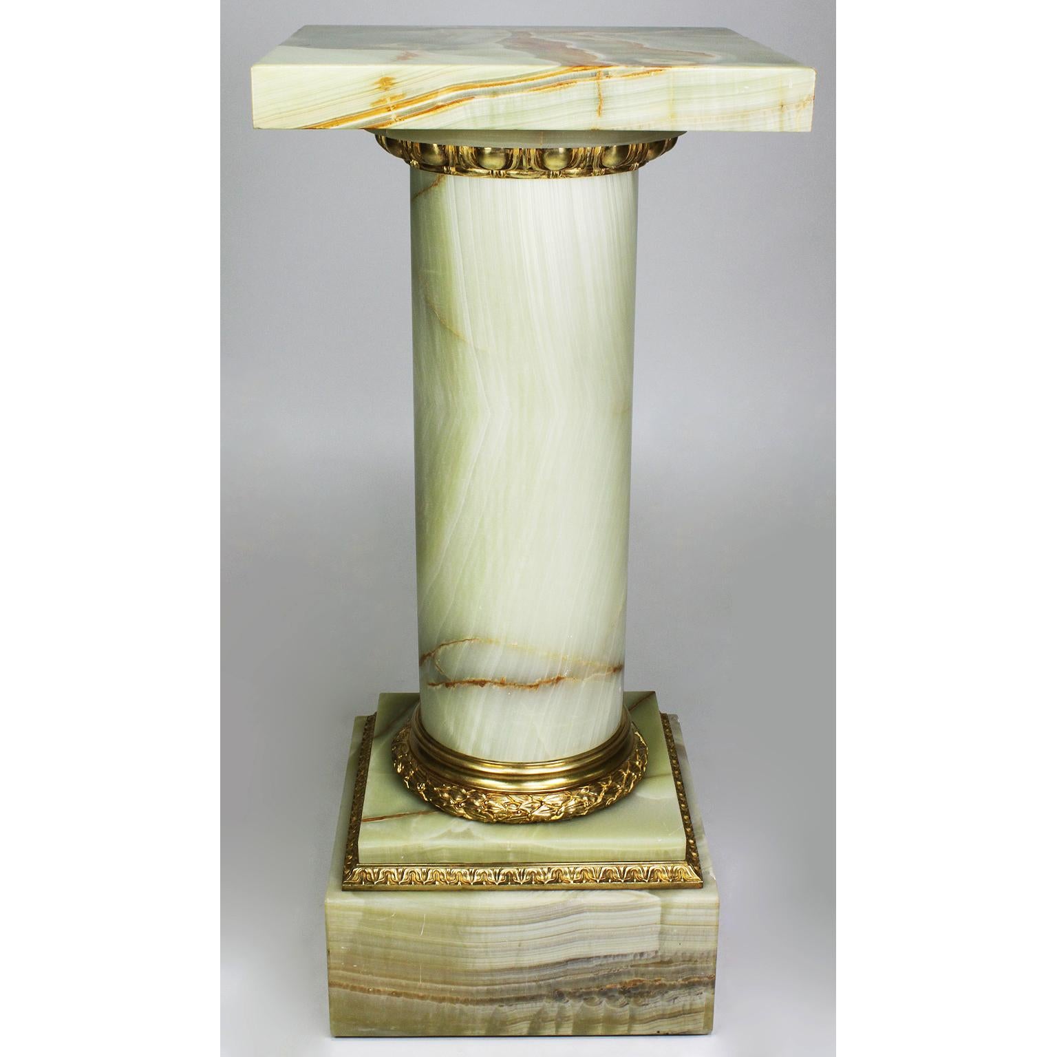 A fine French 19th-20th century Louis XVI style onyx and ormolu-mounted pedestal stand. The cylindrical shaped onyx center stem crowned with egg and dart ormolu mount and a swiveling square top, supported by a square shaped onyx base with a laurel