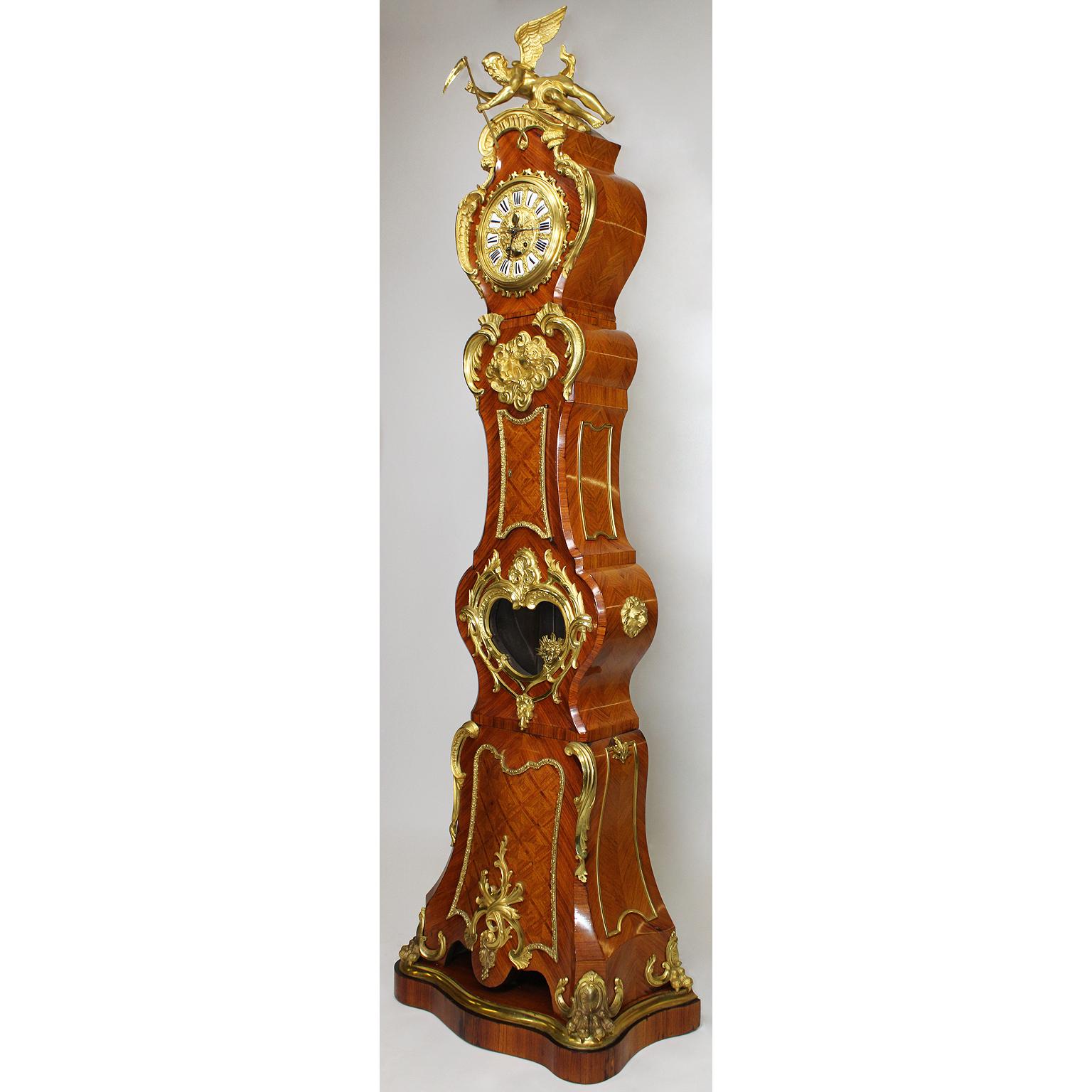 A fine French 19th-20th century Régence style gilt bronze mounted tulipwood parquetry regulator longcase clock, after the 18th century model by Julien Le Roy (French, 1686-1759) and Charles Cressent (French, 1685-1768). The asymmetrical