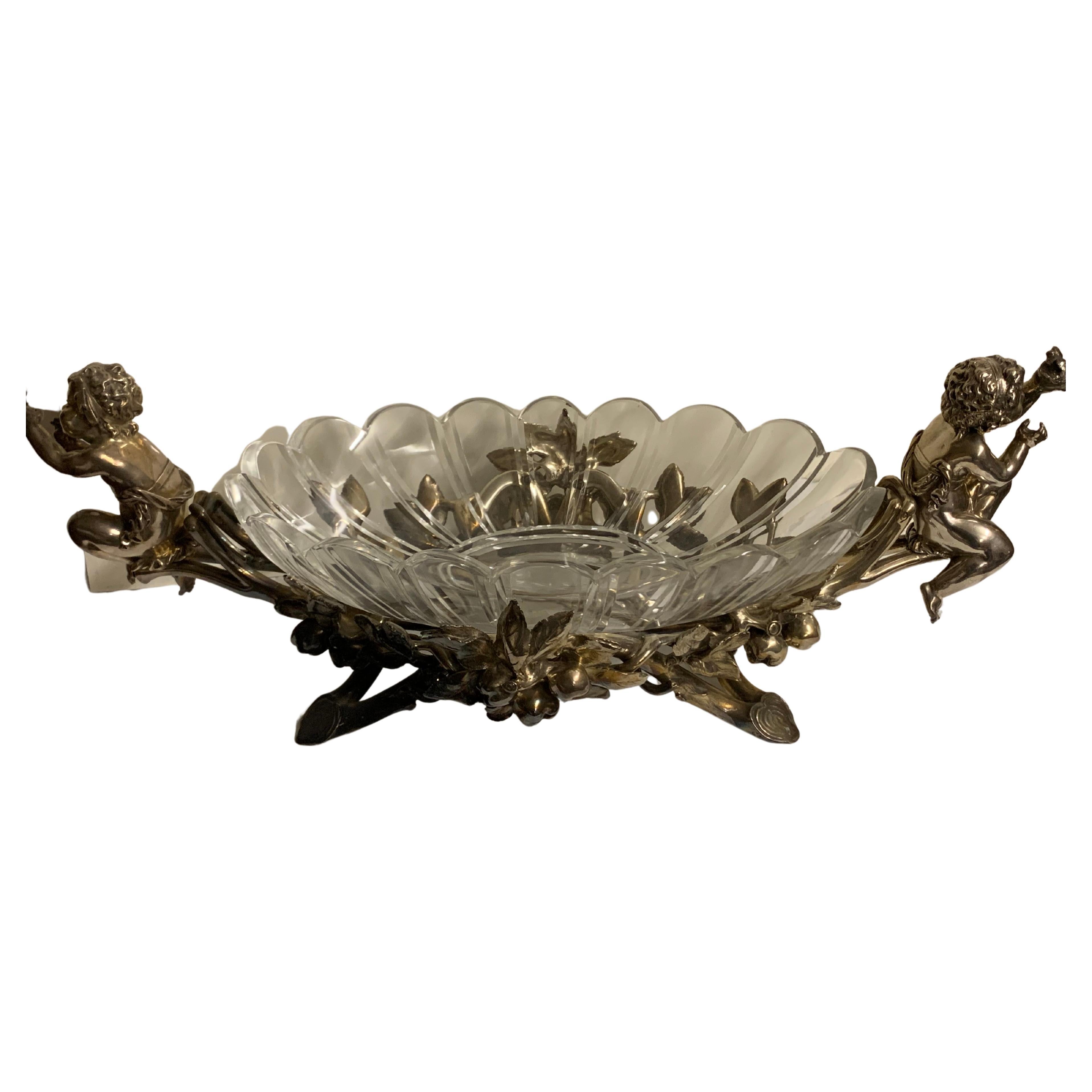 A very fine 19th-20th century Cristofle&Cie louis XV style silvered.
Figural centerpiece with a circular scalloped crystal bowl ,the center-dish flanked by two seated putti,one holding a bird and the other one a newborn chick on the nest ,the base