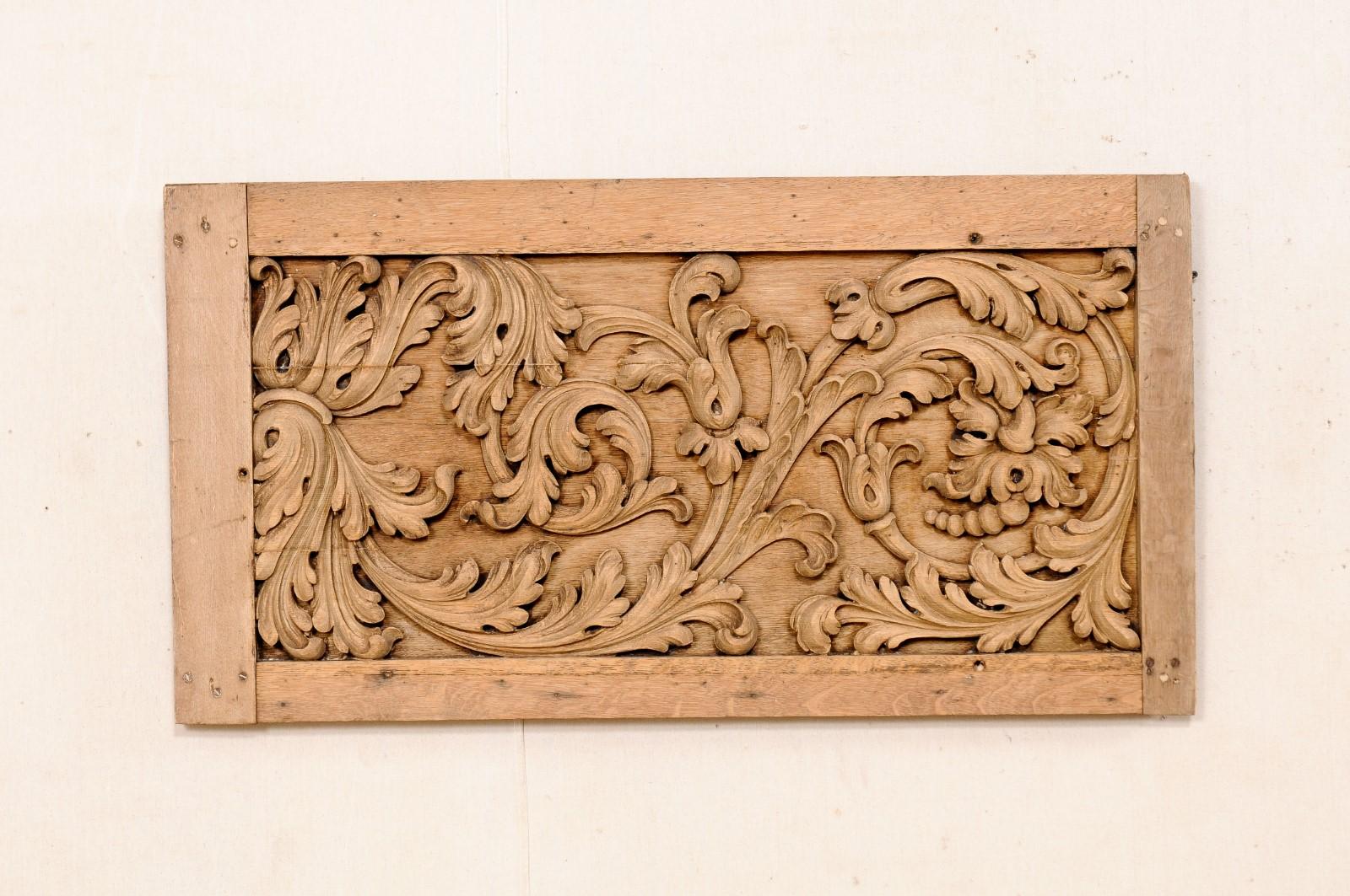 A French carved-wood plaque from the 19th century. This antique wall decoration from France features a rectangular-shaped frame, comprised of straight-boards, with center adorn in a hand-carved relief motif of scrolling acanthus leaves. There is a