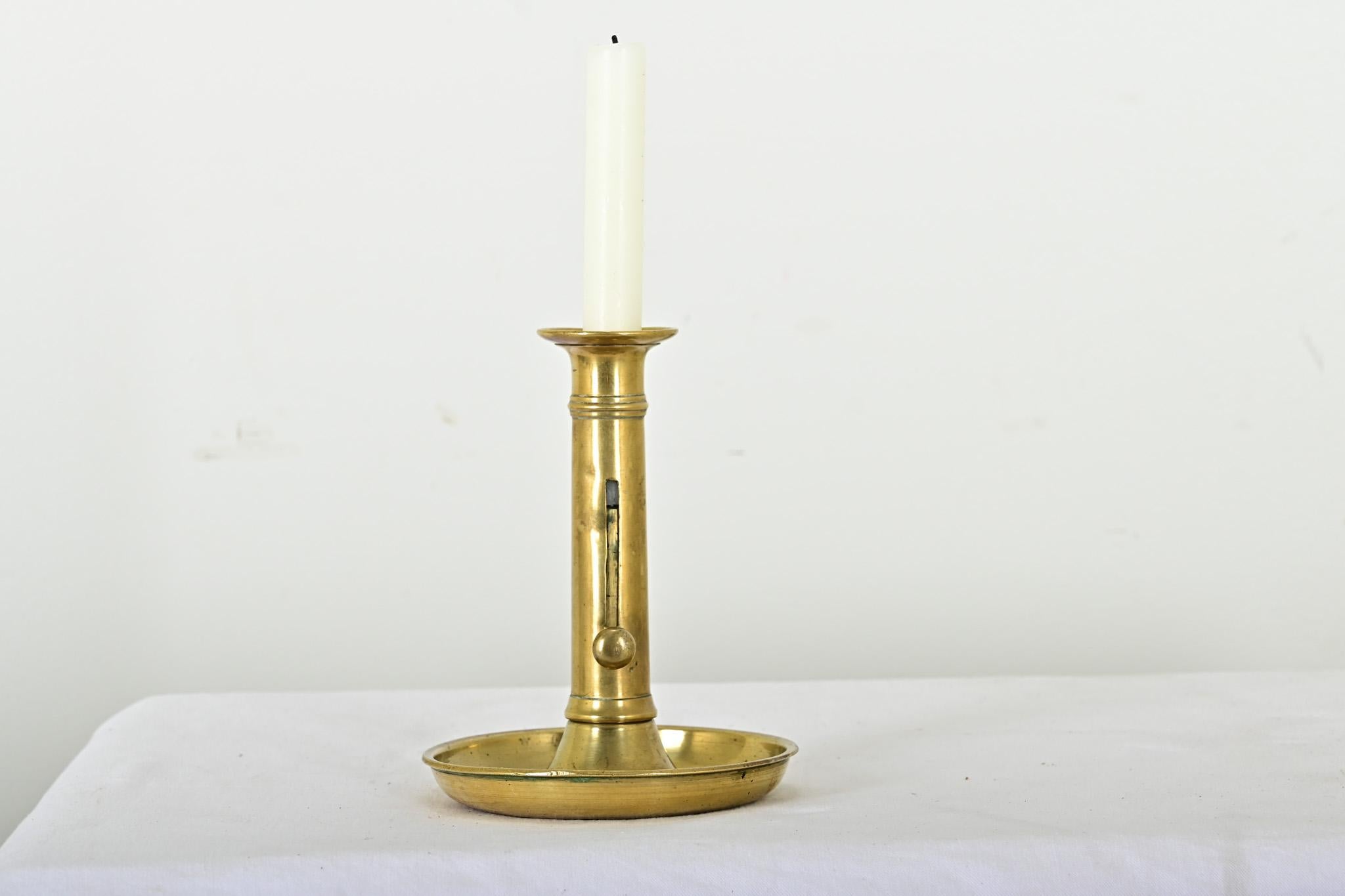 Un affascinante candeliere francese del XIX secolo in ottone con regolatore dell'altezza della candela funzionante. Sorprendentemente pesante per la forma sottile ed elegante. L'incantevole patina e le irregolarità testimoniano che questo pezzo è