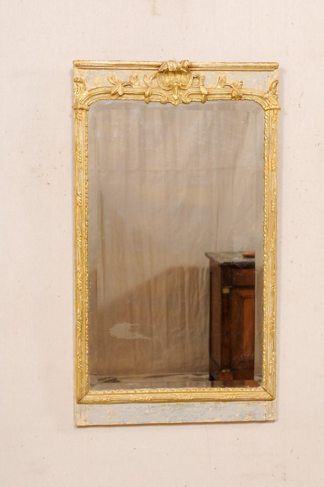 A French rectangular mirror, with carved and painted wood surround, from the 19th century. This antique mirror from France has a rectangular-shaped mirrored glass center, with nicely carved wood frame featuring a curled acanthus leaf and shell at