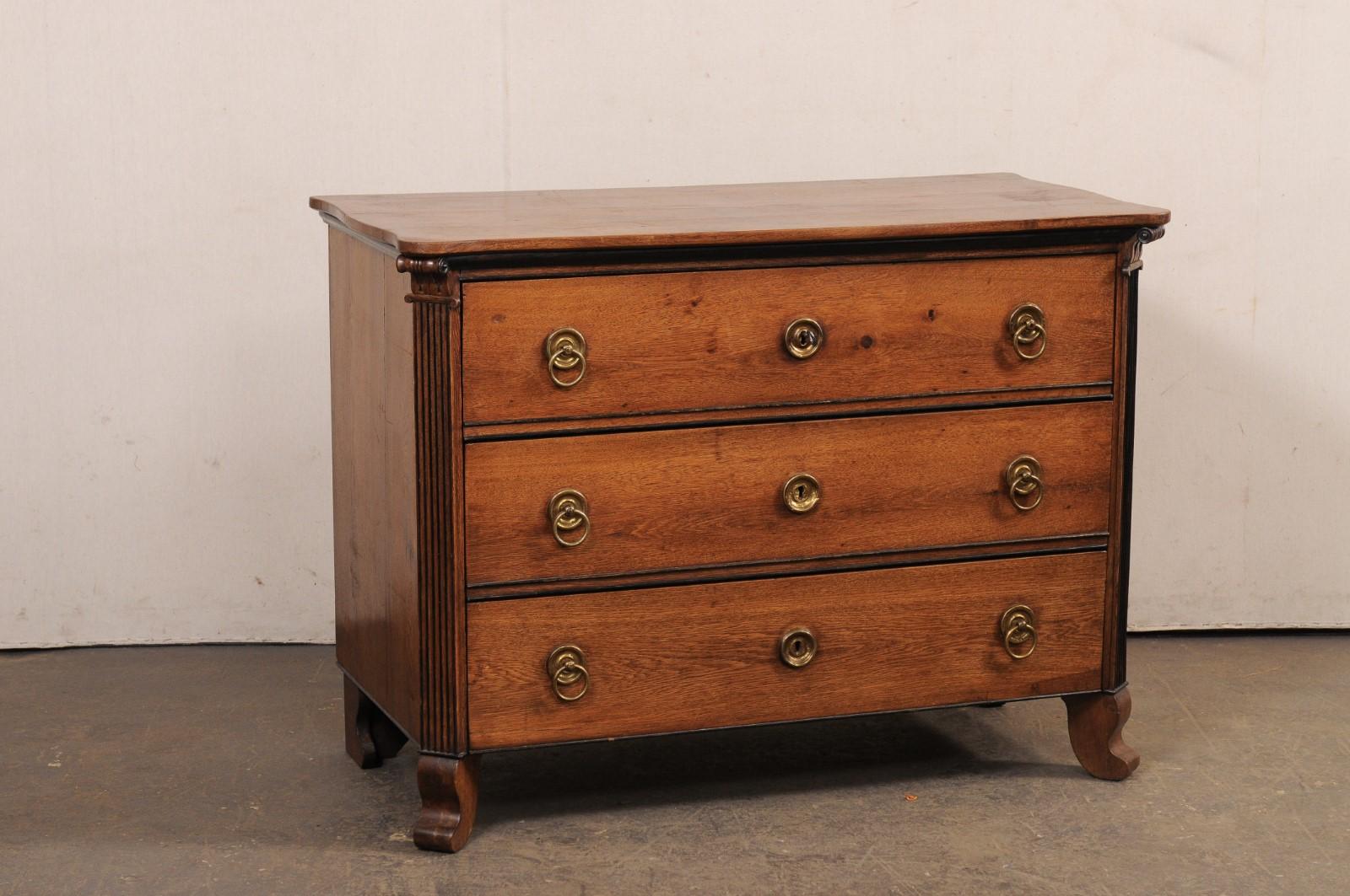 A French carved wood three drawer commode from the 19th century. This antique chest from France has a rectangular-shaped top with subtle scalloped edges about the front and both sides, and prominently rounded front corners. It slightly overhangs the