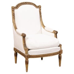 Chaise Bergère de style Louis XVI du 19e siècle, tapissée et sculptée en bois.