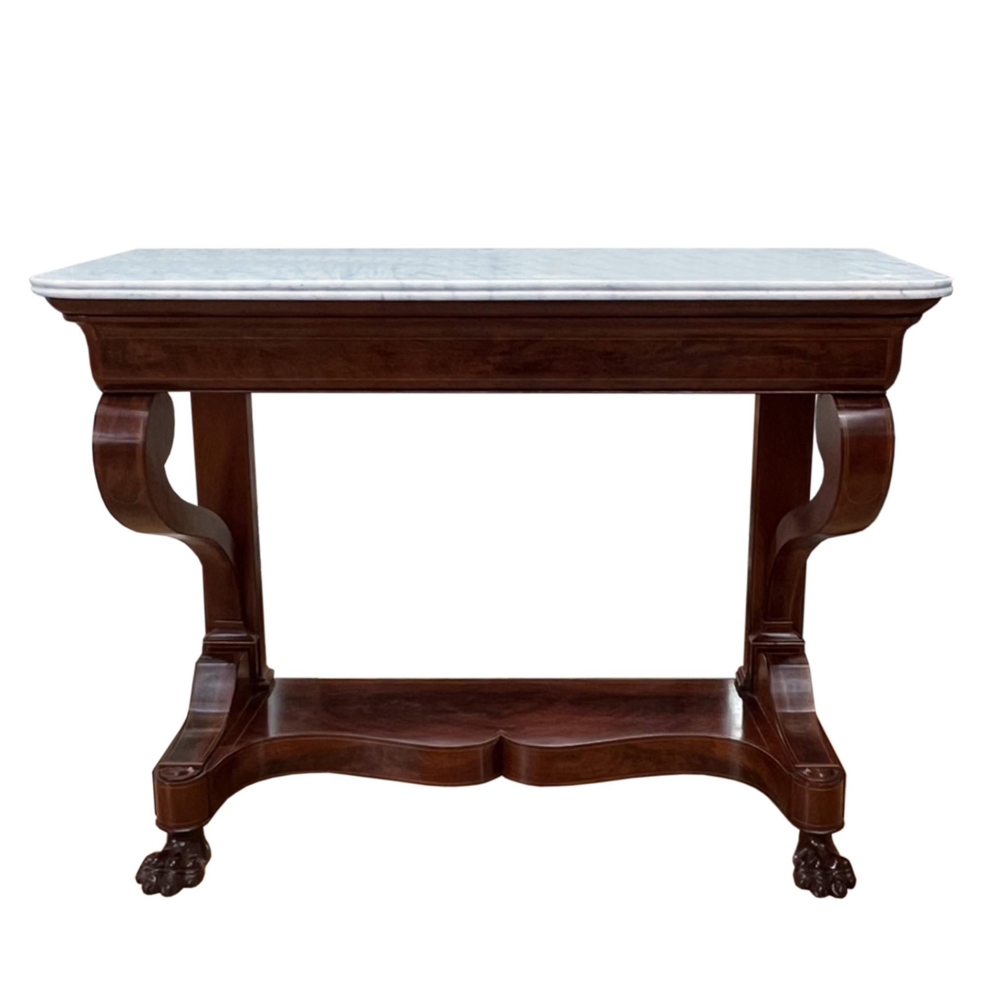 This large console table is made from richly coloured mahogany veneers with a marble top.

It was made in the 19th century in France and demonstrates real quality of work. Please take a look at all the photographs to see the wonderful lion's paw