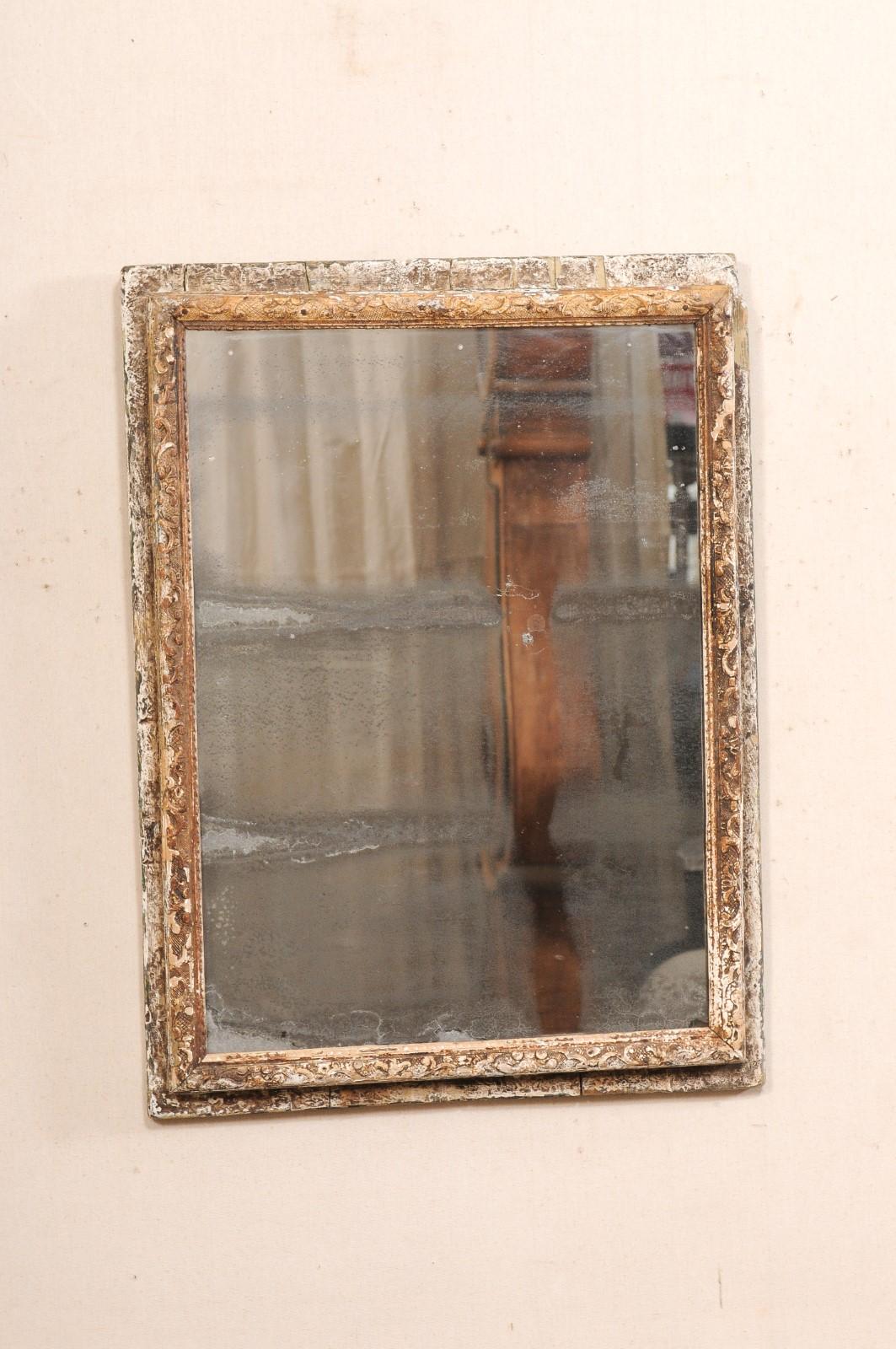 Miroir français en bois sculpté, avec verre et peinture d'origine, datant du 19e siècle. Ce miroir ancien de France est de forme rectangulaire, avec un cadre en bois empilé sculpté d'un motif de feuillage, et une petite garniture perlée bordant le