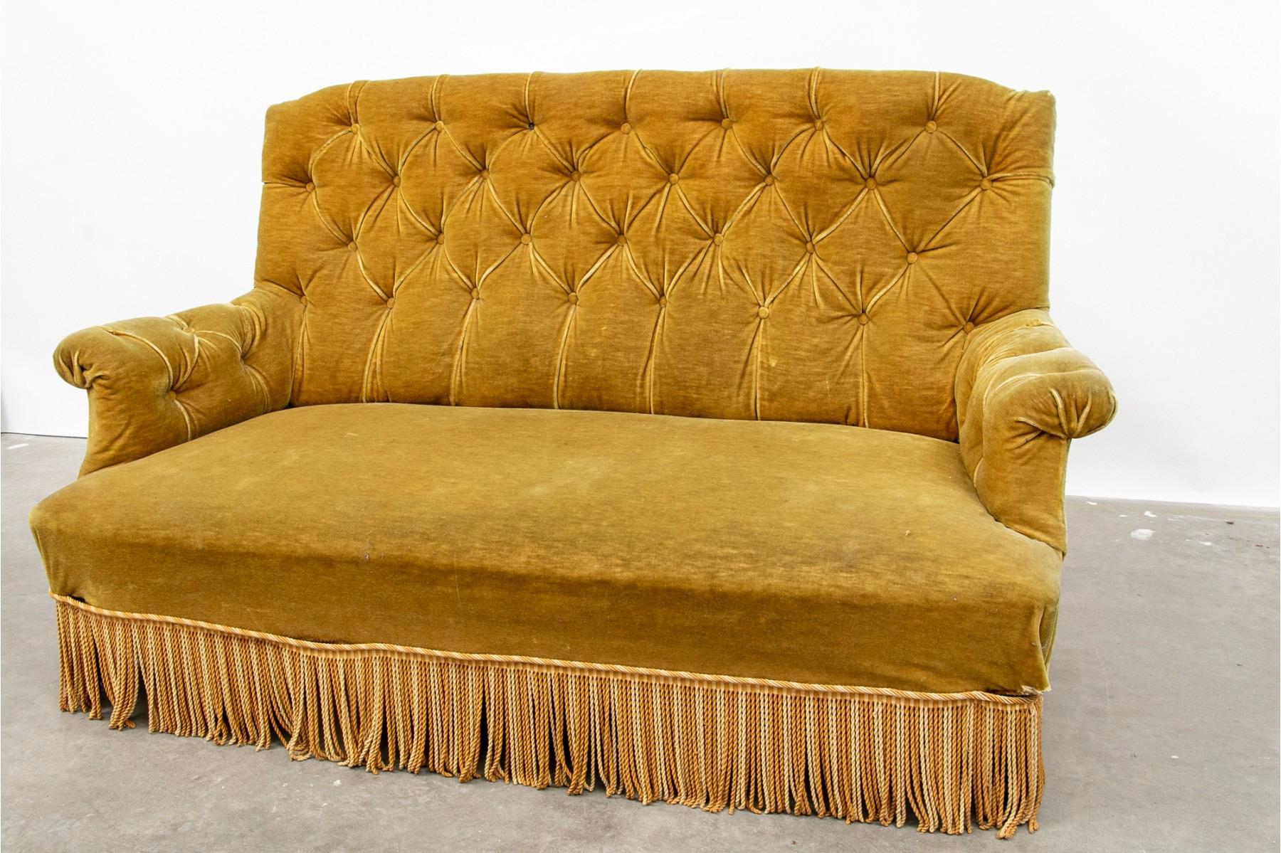 A Napoleon III settee with tufted back and arms, The sofa is upholstered in gold velvet with matching contrasting bouillon fringe and resting on turned legs.

The sofa is in good vintage condition, but the upholstery does show signs of wear