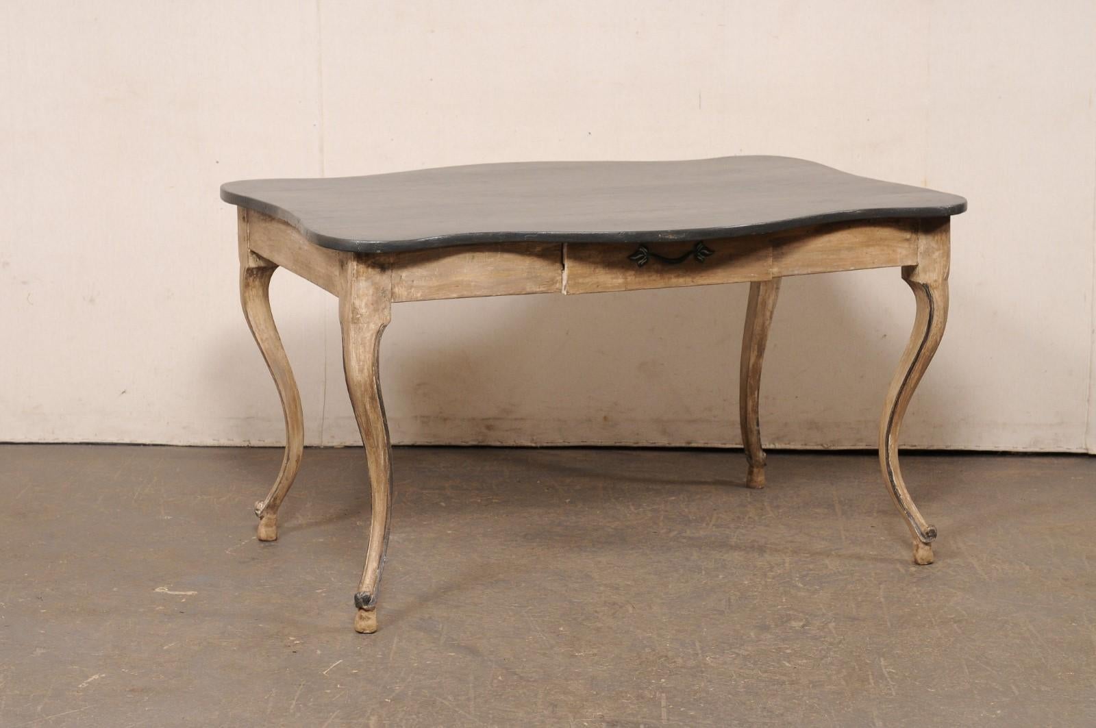 Tavolo (o scrivania) francese in legno intagliato e dipinto, con gambe e bordi superiori sagomati, risalente al XIX secolo. Questo tavolo antico proveniente dalla Francia presenta un piano di forma rettangolare che è stato piacevolmente enfatizzato