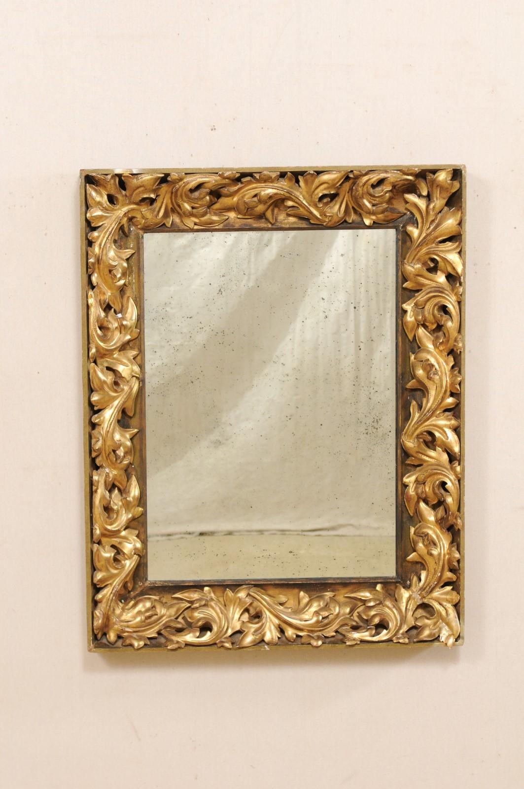 A French nicely carved giltwood mirror from the 19th century. This antique rectangular-shaped mirror from France features beautifully decorative, Rococo style, three-dimensionally carved leafy scrolls, set within the surround, framed with a flat