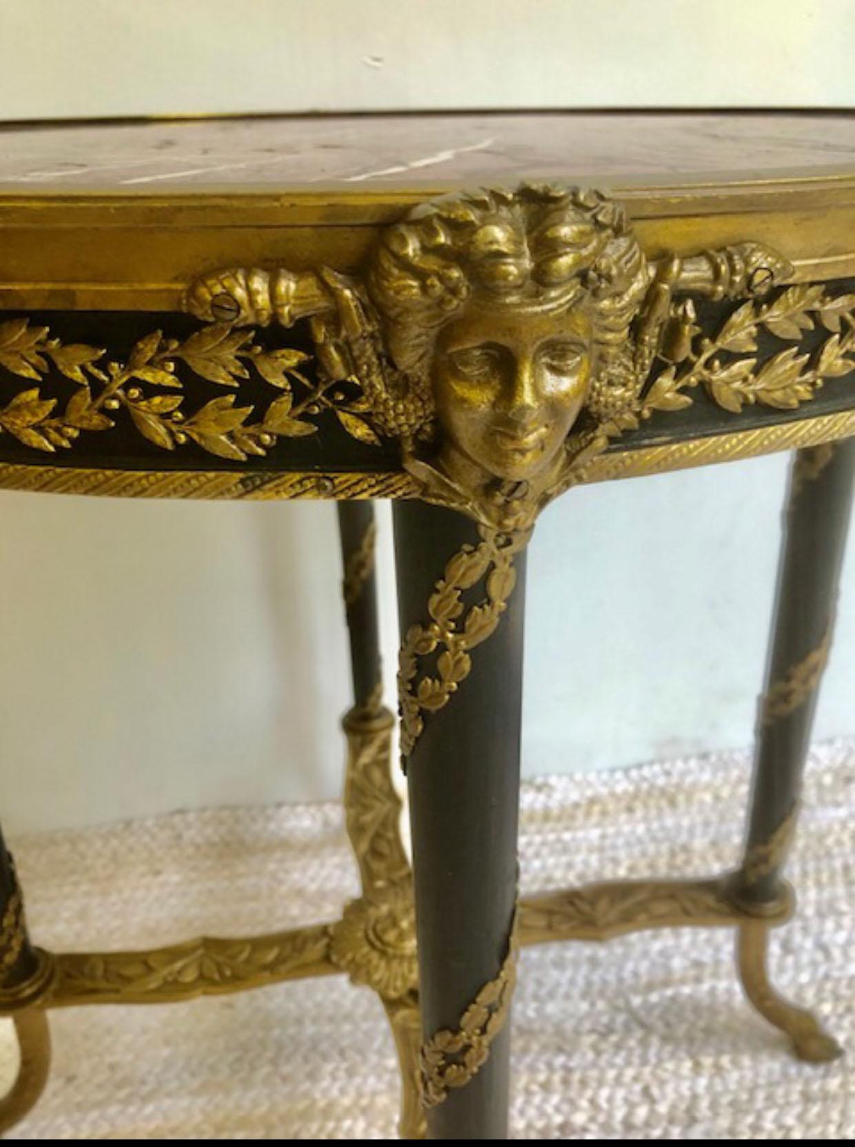 Rare 19th C signed French bronze ormolu mounted hoof or paw foot round bouillotte occasional end side table.
Wonderful table with bronze stretcher, legs topped off with classical bronze face, inset with marble. Wood legs wrapped with bronze leaf