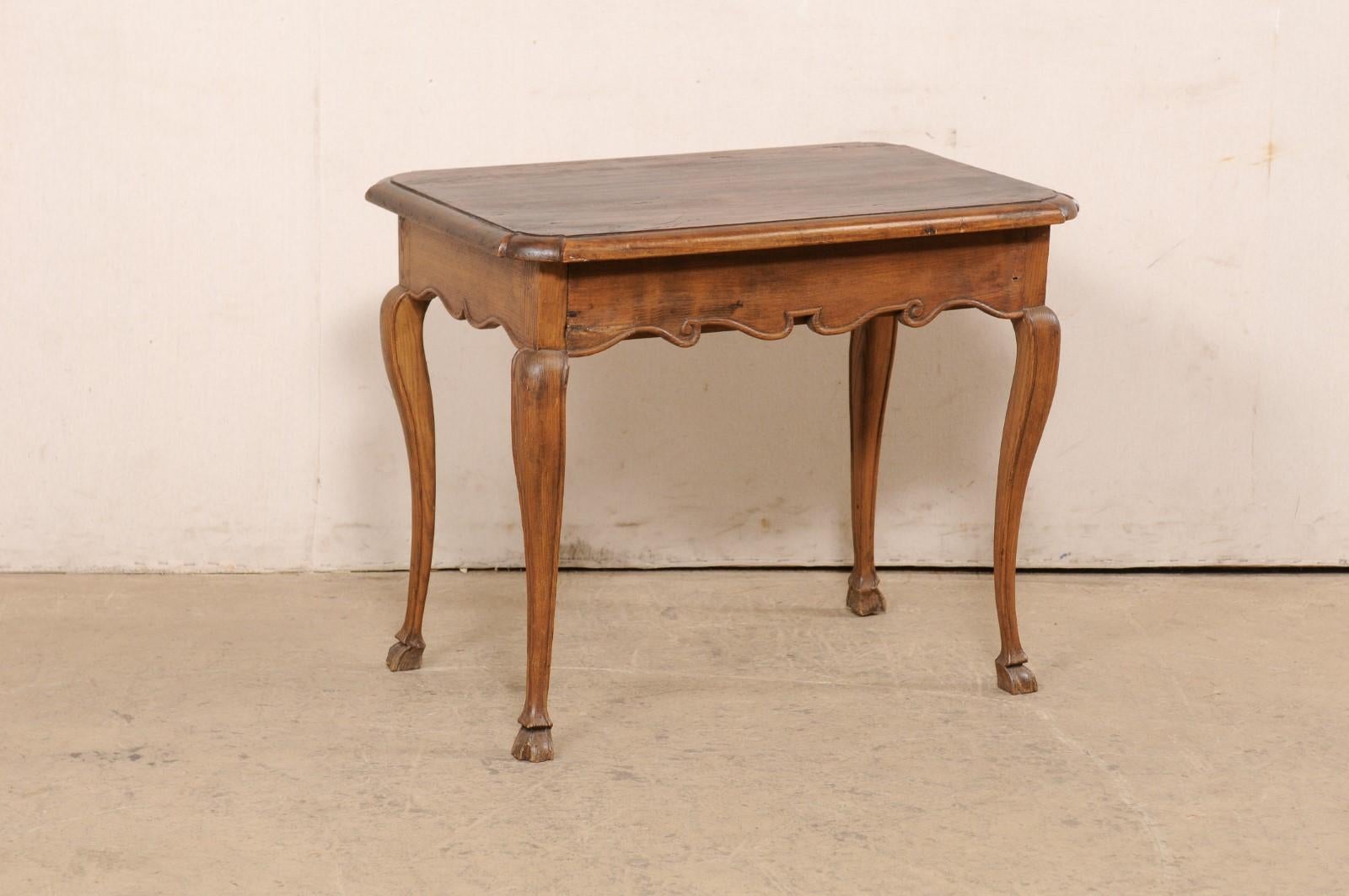 A French carved-wood occasional table with drawer from the 19th century. This smaller-sized antique table from France has a rectangular-shaped top with rounded corners, which is slightly overhanging. The apron houses a single drawer hidden along one