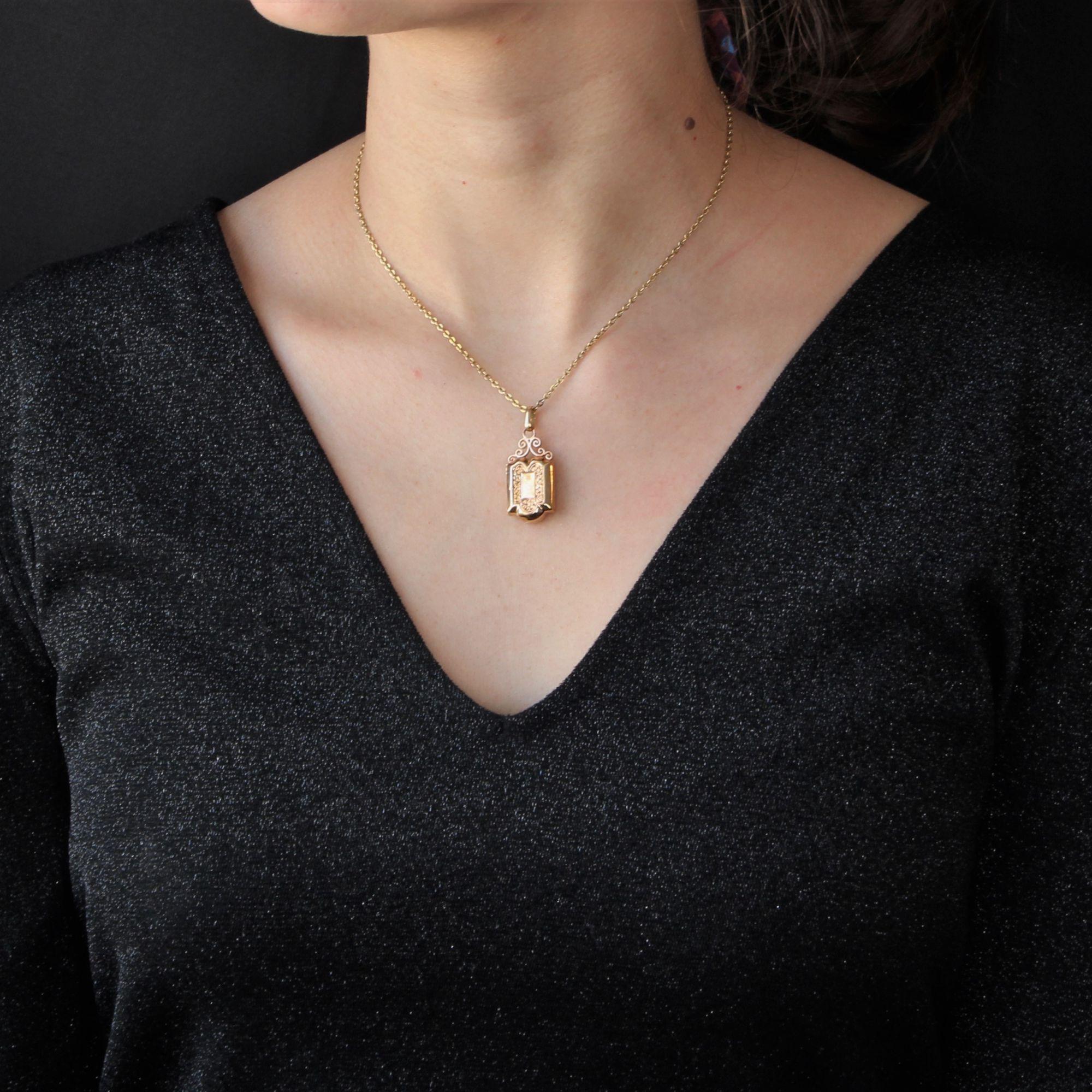 Medaglione in oro rosa 18 carati, marchio di fabbrica con testa d'aquila.
Delizioso piccolo ciondolo antico, è di forma rettangolare sormontato da arabeschi in oro che reggono la bélière. La faccia anteriore è traforata con decorazioni, anch'esse in