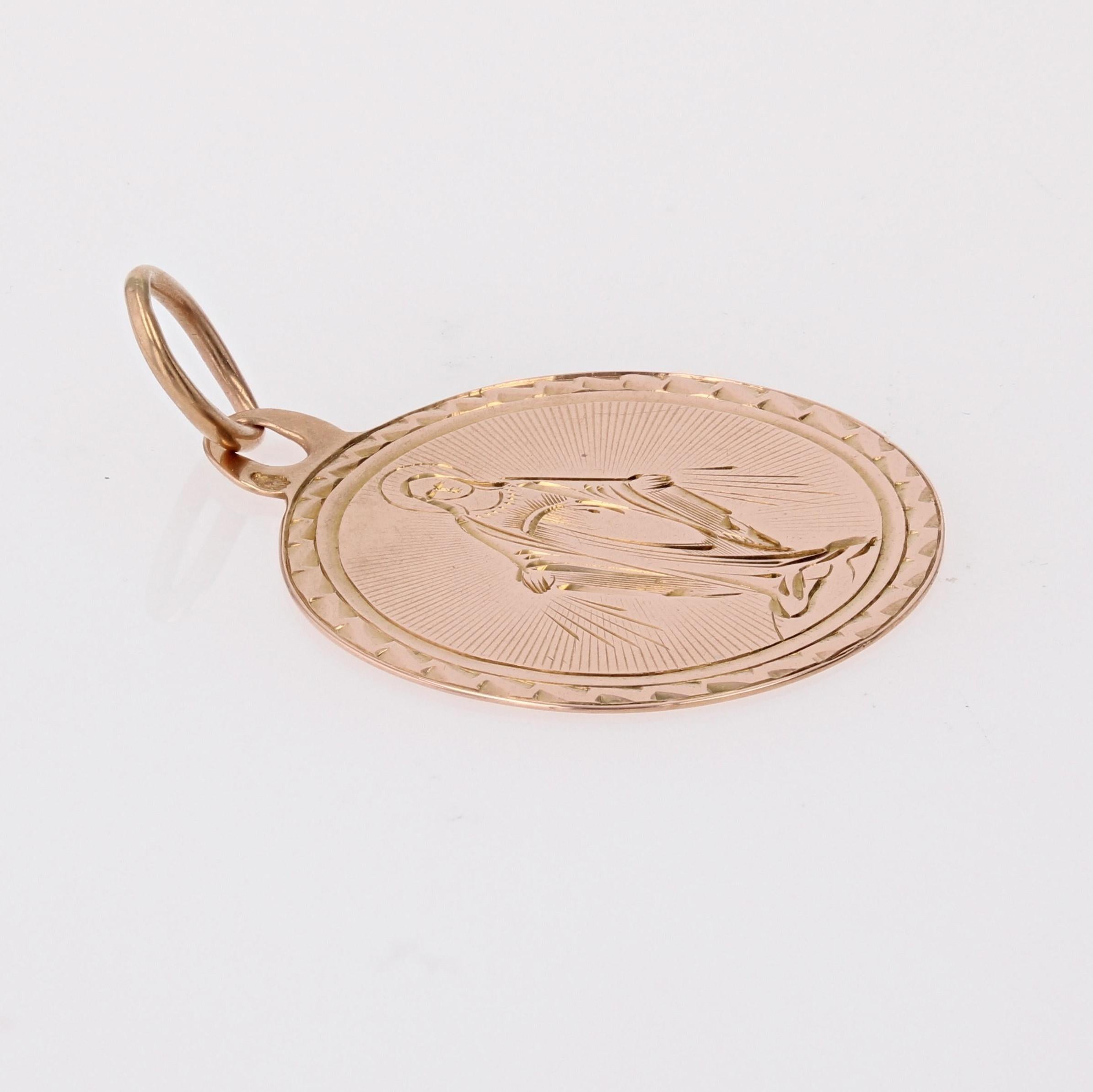 Medal in 18 karat rose gold, eagle head hallmark.
Antique round shape medal, it is engraved with the Virgin Mary holding her arms open and encircled by a chased decoration. The back of this religious pendant is engraved: 
