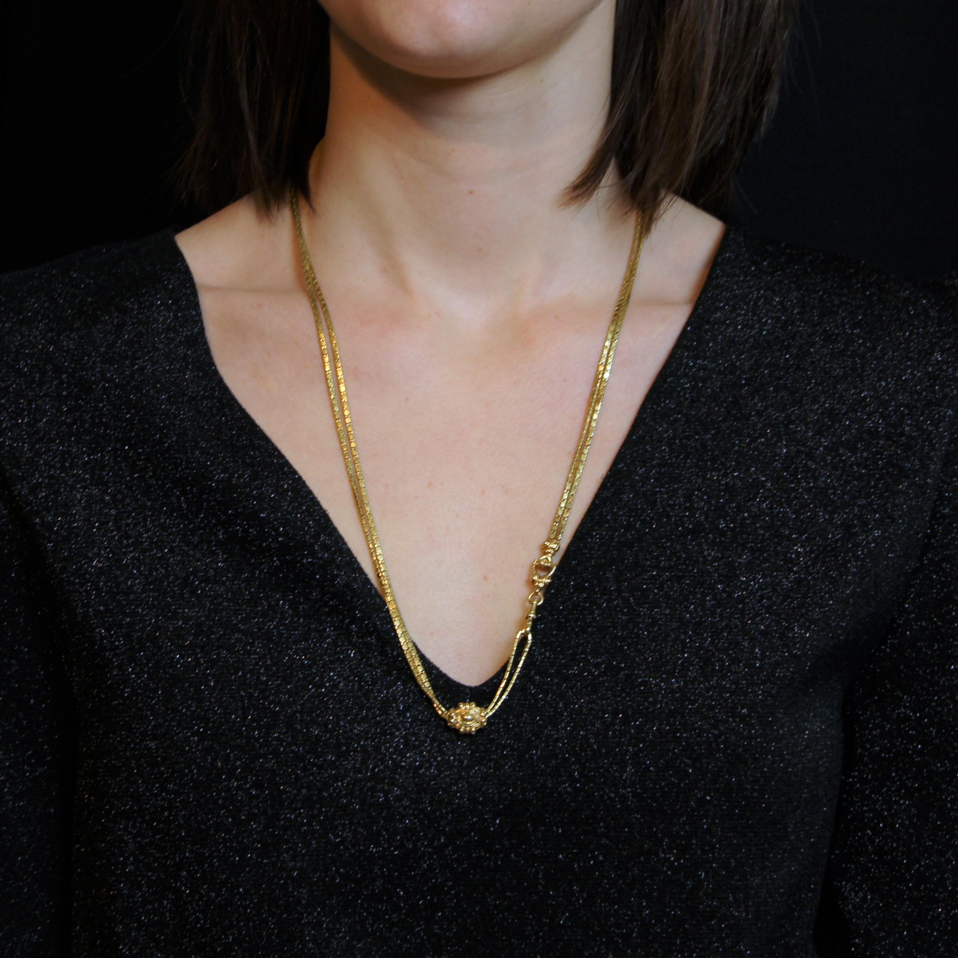 Necklace in 18 karat yellow gold, eagle head hallmark.
Antique watch chain, this antique necklace is formed of a snake style mesh which finishes in an end by a fastener chiseled of floral patterns, of a gloved hand and of a clasp snap hook. A