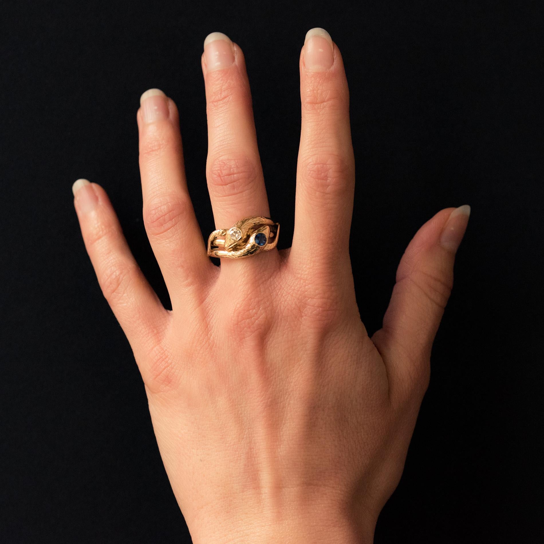 Ring in 18 karat yellow gold, eagle's head hallmark.
This superb antique ring represents 2 snakes coiled on themselves whose heads form the top of the ring. One is set with an antique brilliant- cut diamond, the other is set with a blue
