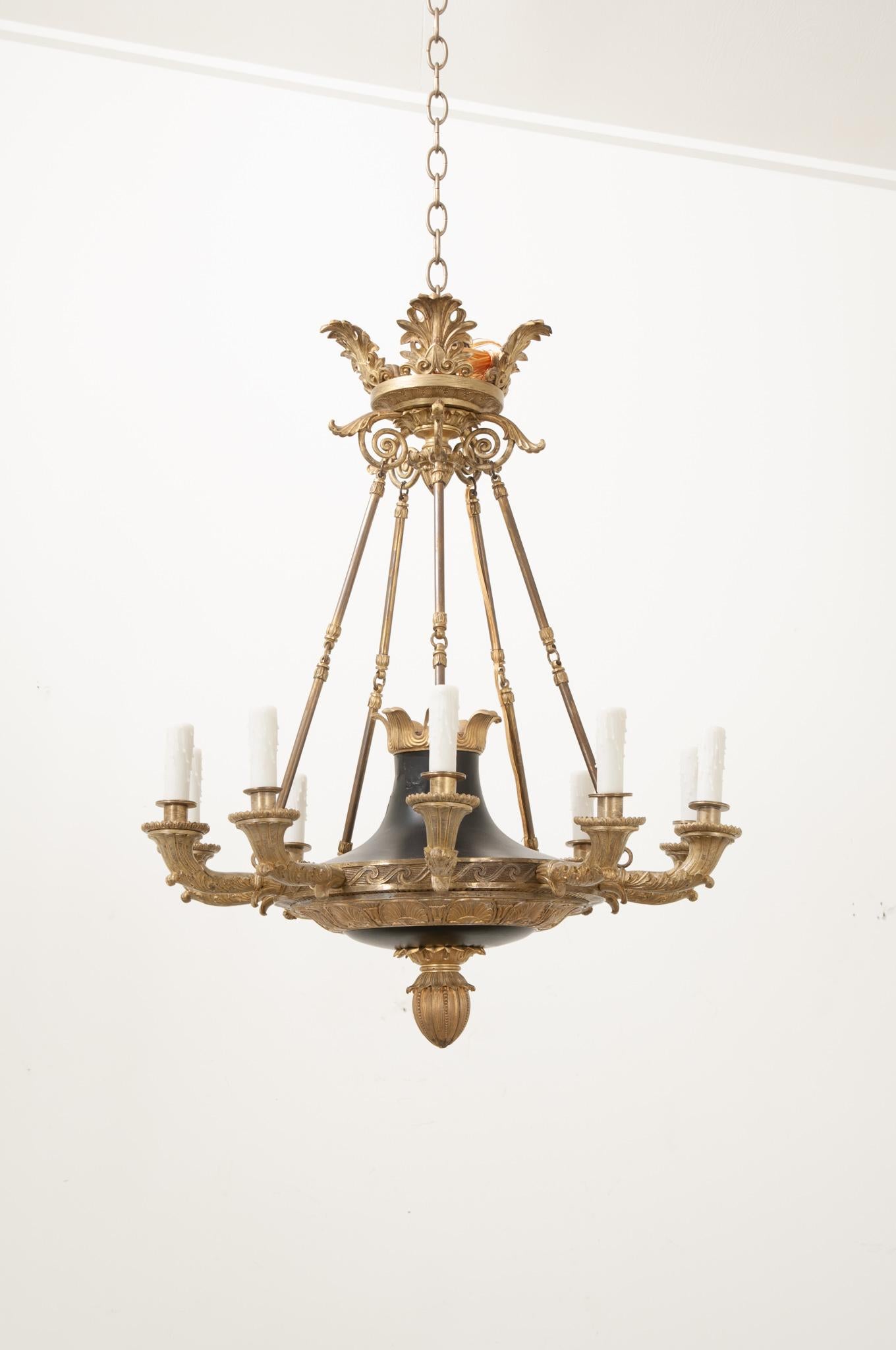 This eye-catching chandelier was crafted in France in the early 1800’s during the 1st Empire period. Composed of a patinated bronze bowl with a cone-shaped neck. The bowl’s base is decorated on its underside with a brass  artichoke drop finial and