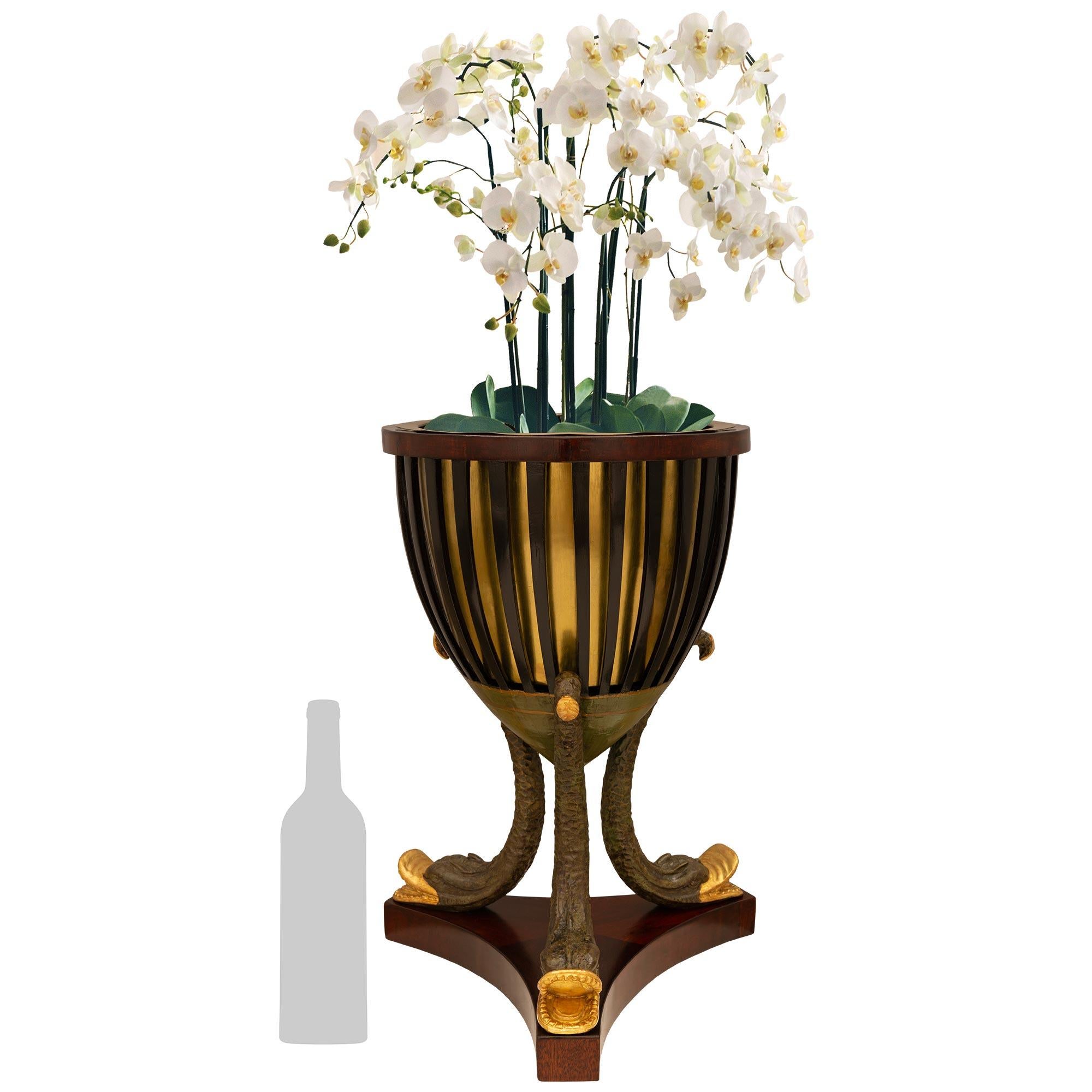 An elegant and most unique French 19th century 1st Empire Period ebonized Fruitwood, Mahogany, Brass, patinated Wood, and Giltwood Jardinière planter, circa 1820. This truly impressive Jardinière is raised by three patinated wood dolphin shaped legs