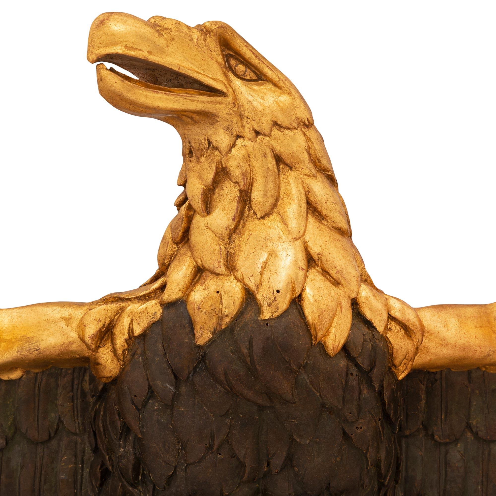 An impressive and extremely decorative French early 19th century 1st Empire period giltwood and polychrome eagle wall decor. The unique wall decor depicts and a striking wonderfully executed open winged eagle with exceptional attention to detail and