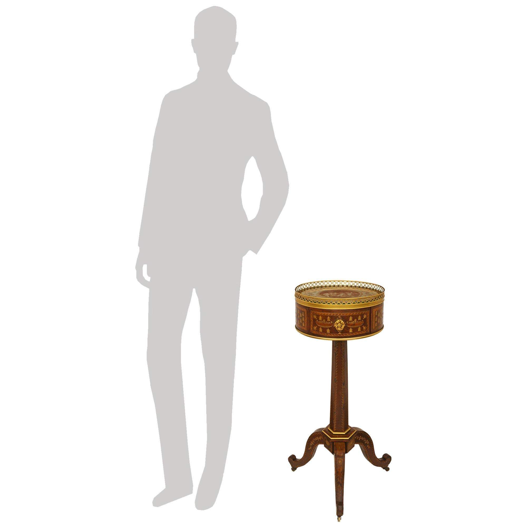 Rare et unique table d'appoint en cuir et bronze doré, datant du début du 19e siècle, vers 1805. Cette charmante table repose sur une base tripode avec des pieds enveloppés de cuir et supportés par les roulettes en laiton d'origine. Chaque pied est