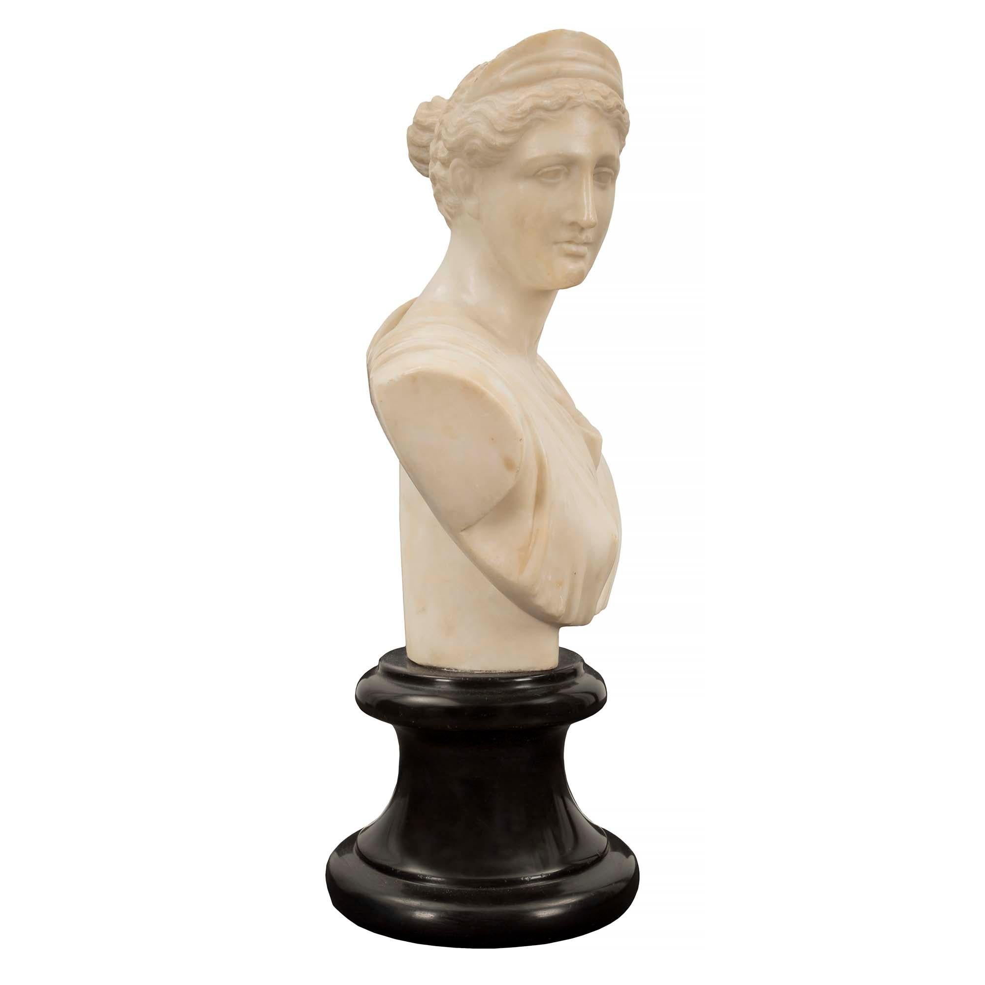 An elegant French 19th century alabaster bust of Diana the Huntress. The beautiful bust is raised by a circular mottled black Belgian marble base. The exceptionally well executed Alabaster bust depicts Diana the Huntress looking to her right draped