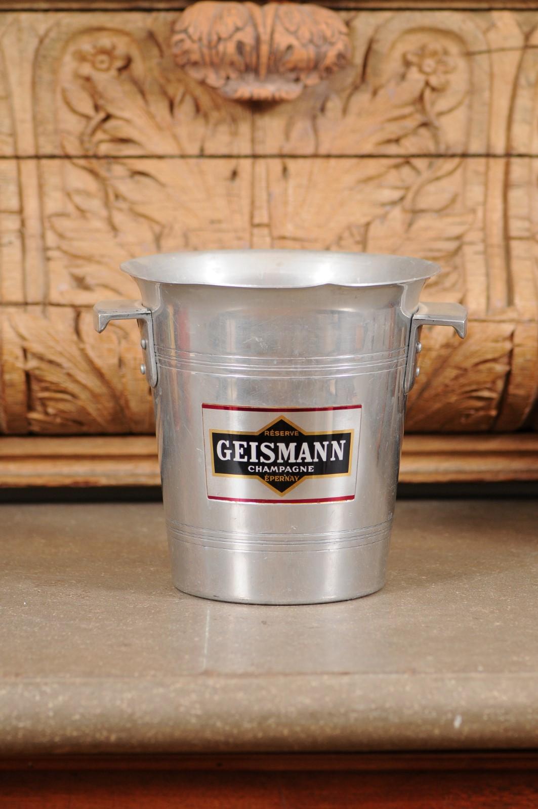 A French champagne bucket from the 19th century, with Geismann Epernay label and lateral handles. Created in France during the 19th century, this aluminum champagne bucket features a circular tapering body showcasing a flaring lip and lateral