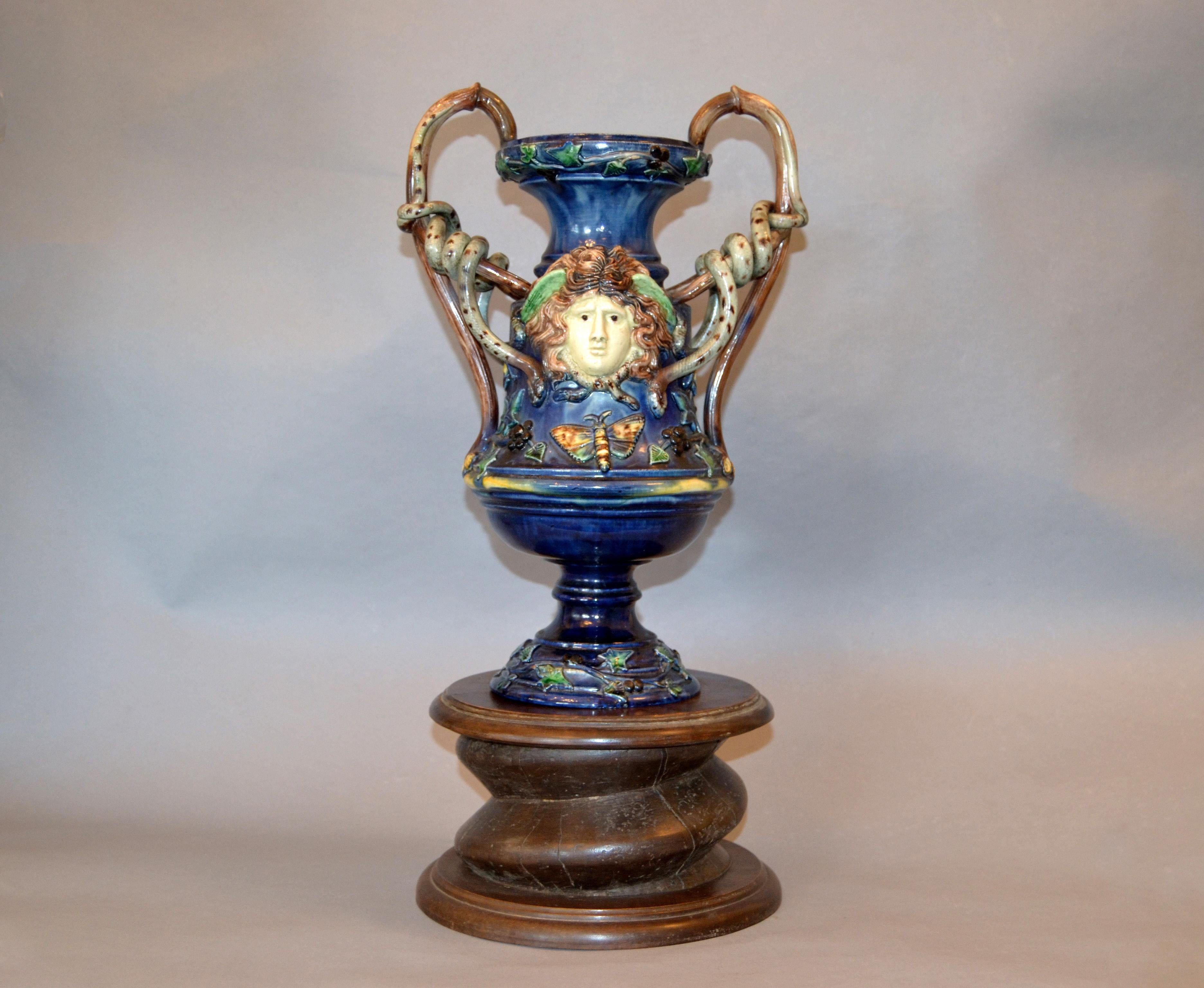 This neoclassical wine themed antique glazed and hand painted ceramic wine jar, vase, decanter was made in France, circa 1890.
The brown handles are shaped like old vines and snakes are surrounding them.
It is decorated with colorful blue grapes,