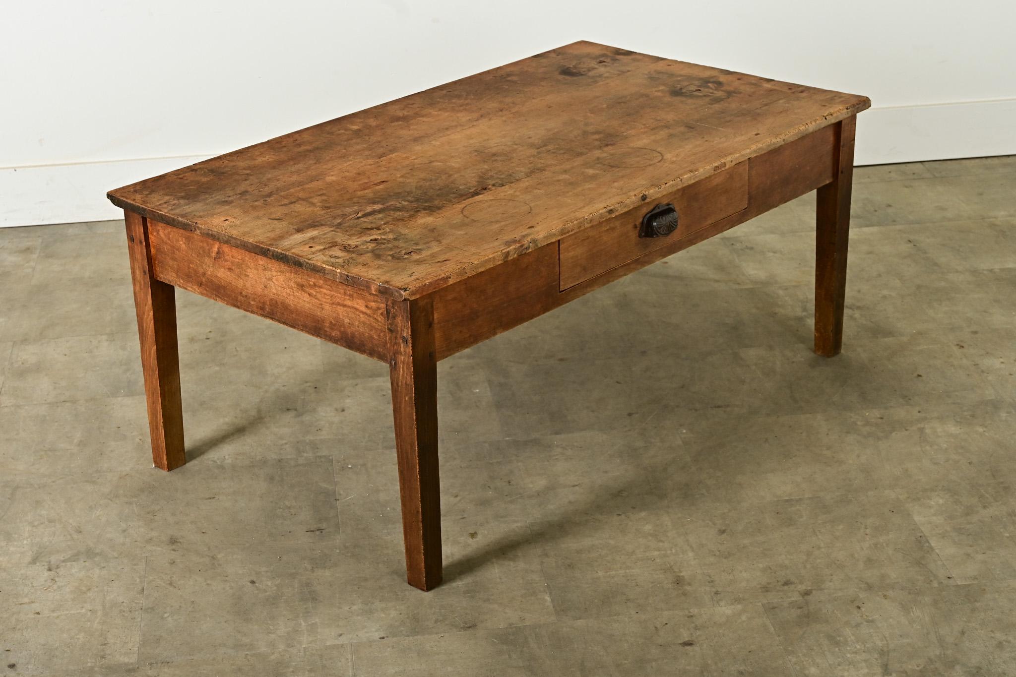 Antique French coffee table, circa 1870, handmade from applewood. The planks of the top feature handsome grain patterns which commingle with the water rings and patina from over a century of use. Within the apron is a single drawer, opened by an